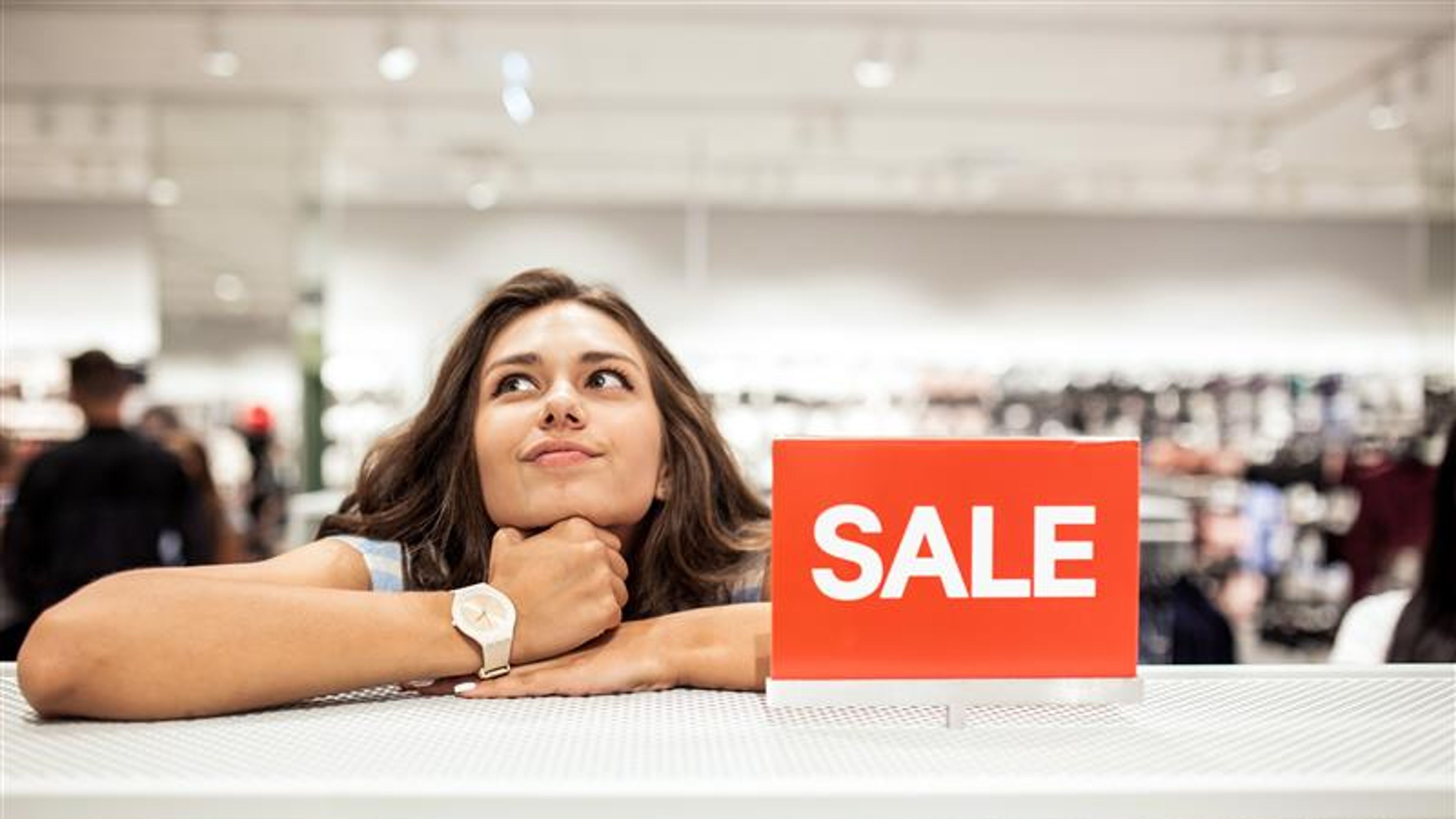 A young friendly slim girl with long hair,wearing casual outfit,is doing shopping in a modern mall 