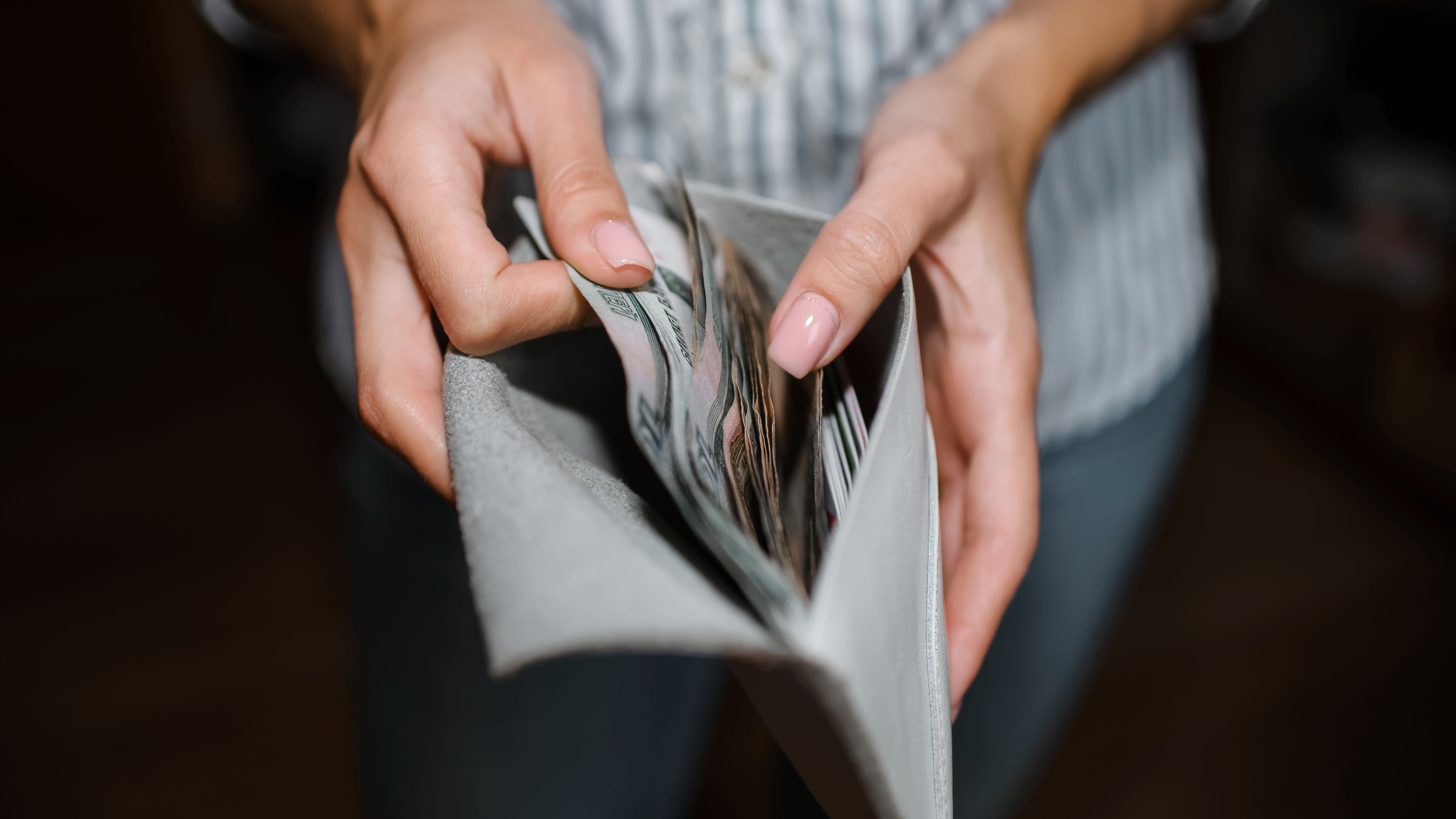 Woman counts money, close-up of a wallet with ruble banknotes. Selective focus, dark background 