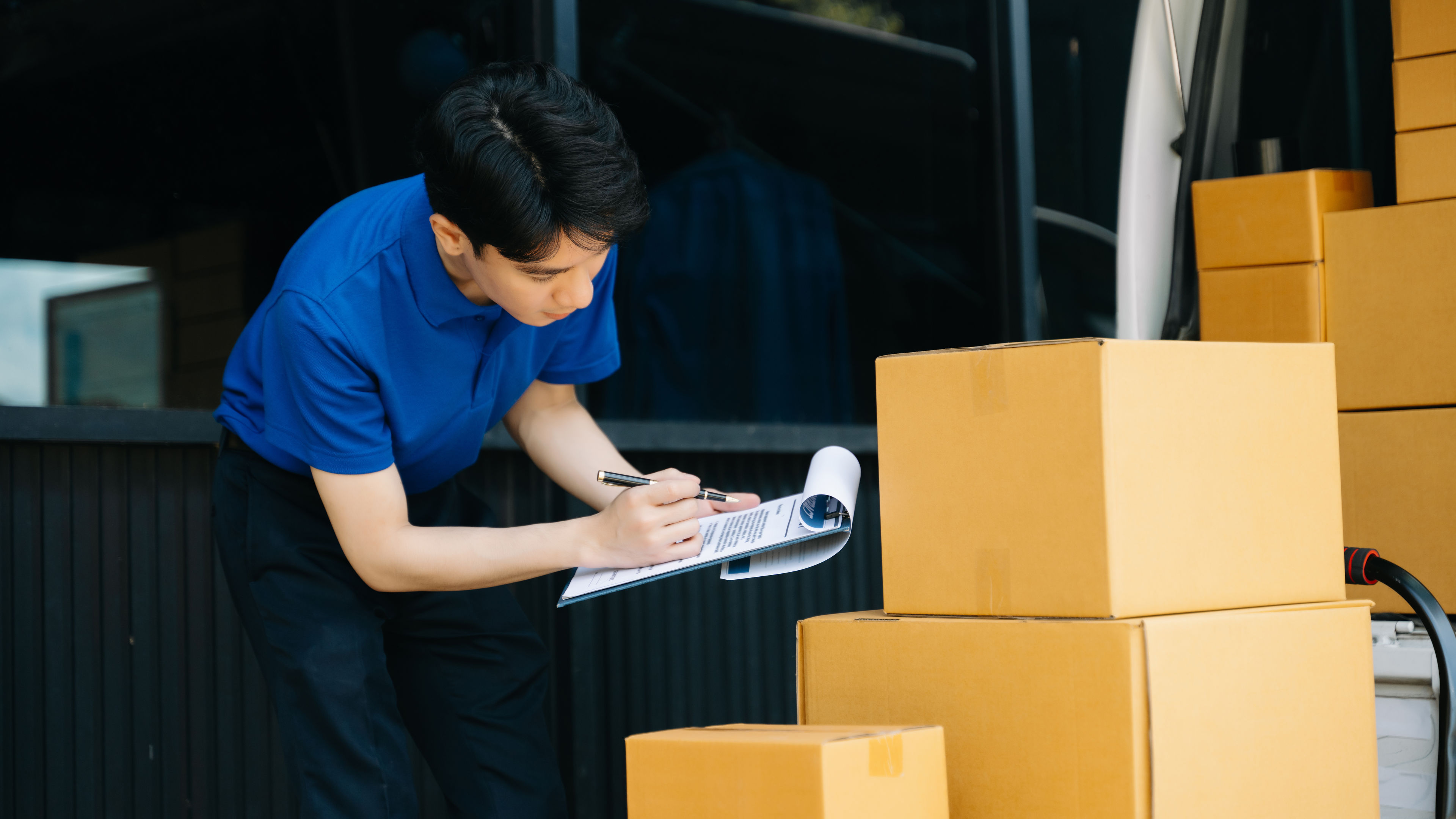 A man checking papers after delivering the orders 