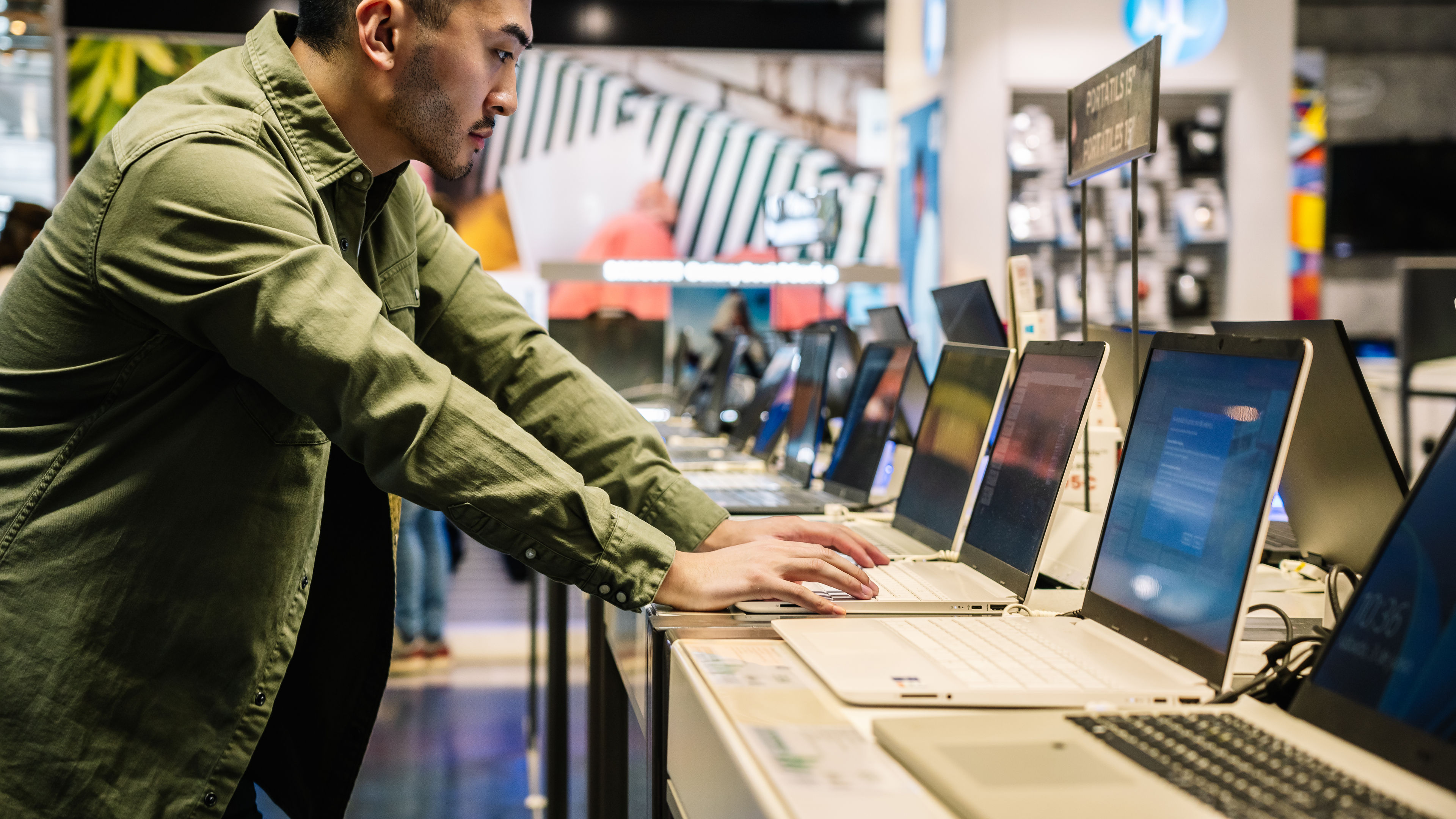 A man looking at a laptop in a shop