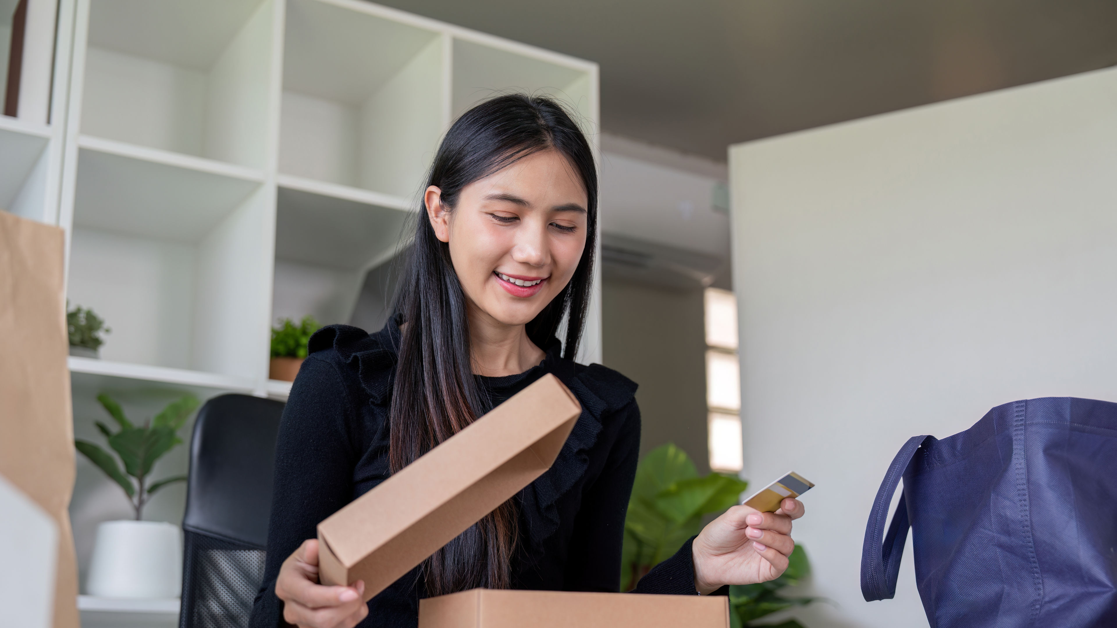 A happy woman opening a package  