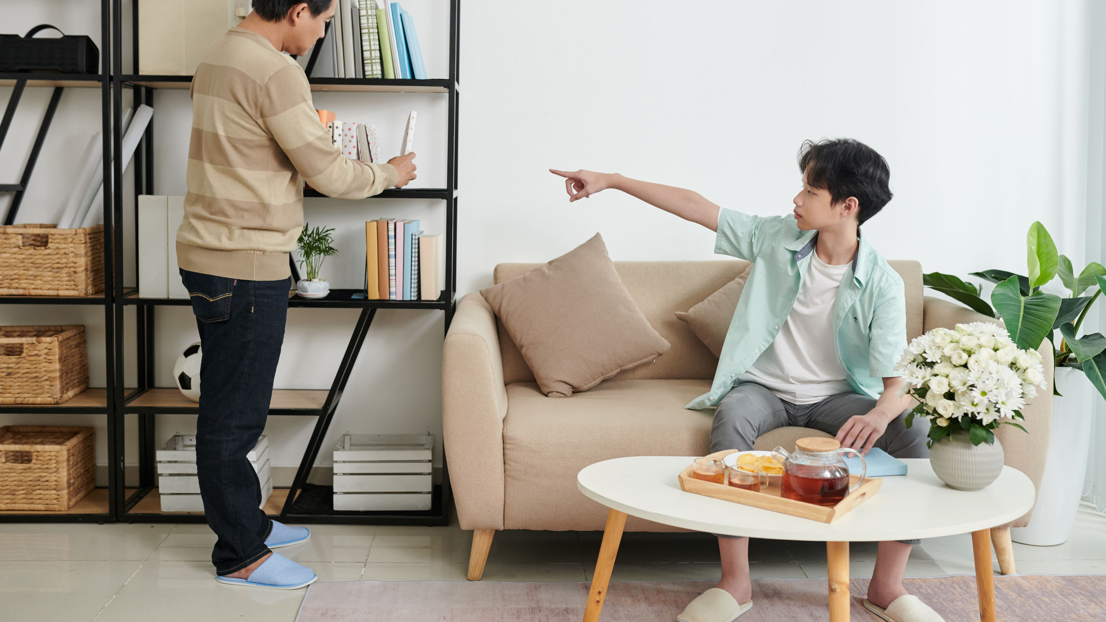 Boy and father arranging bookshelf