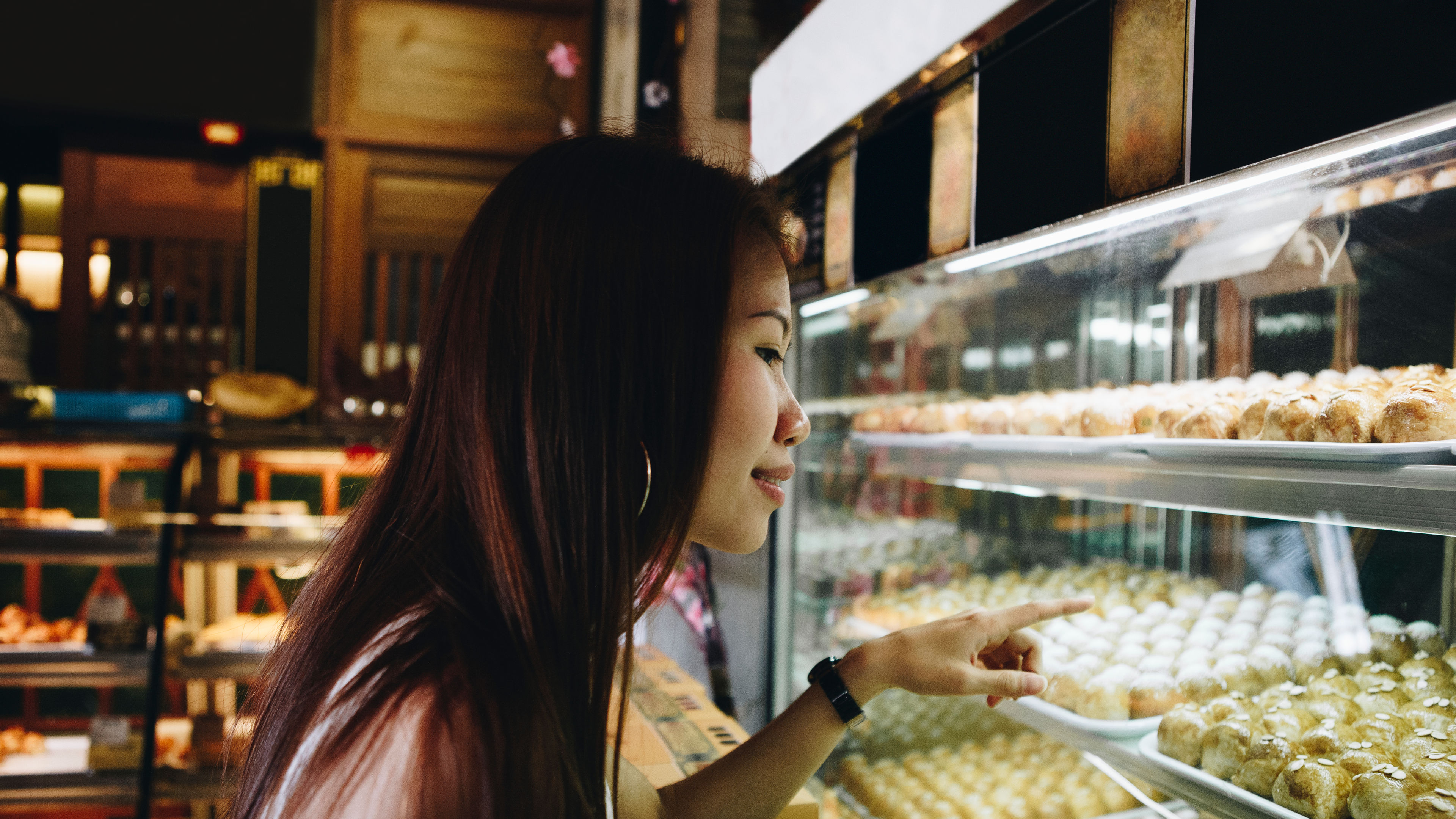 Girl pointing at pastries. 