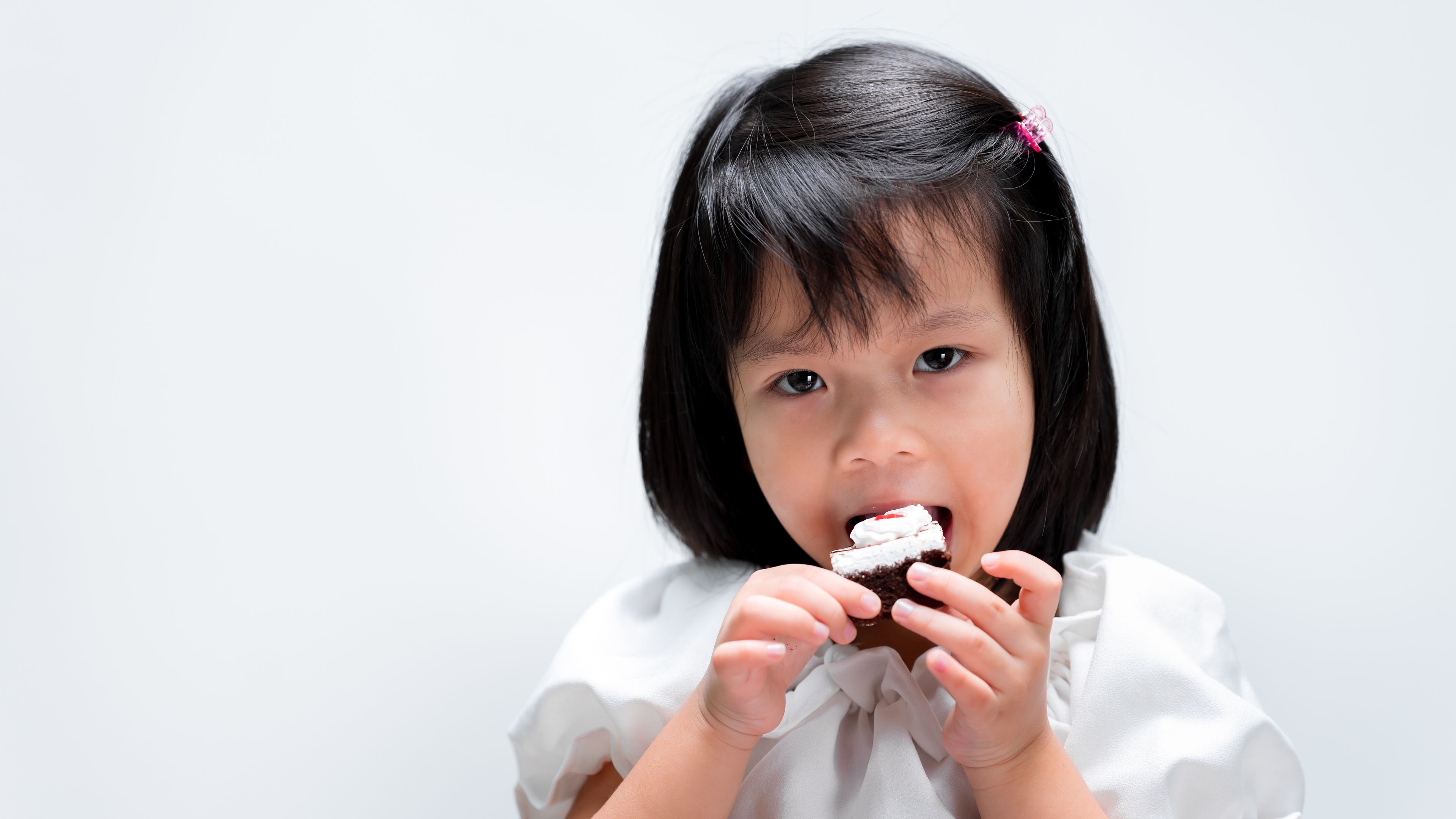 Happy girl eating chocolate cake 