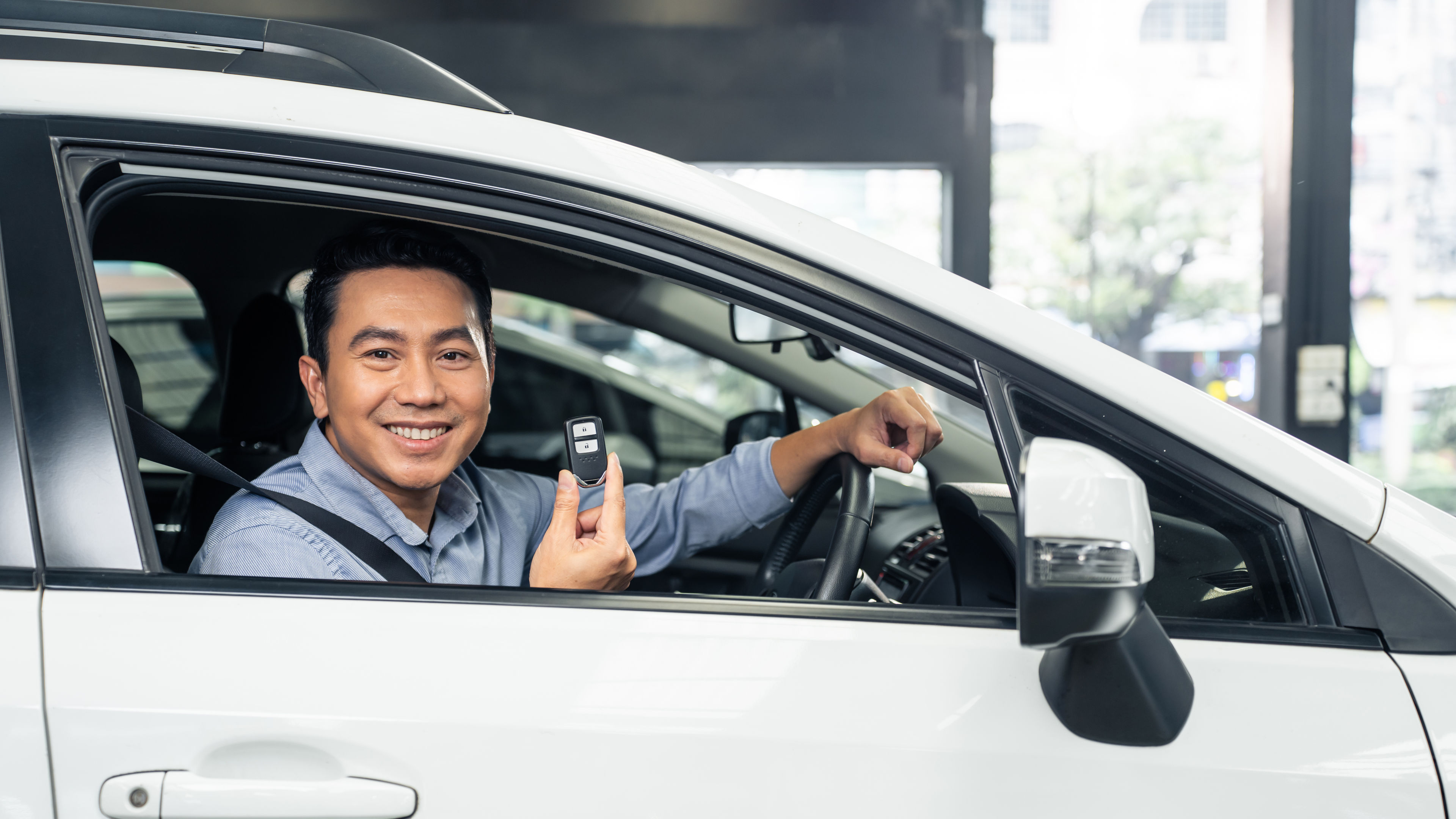 Happy man holding remote car key