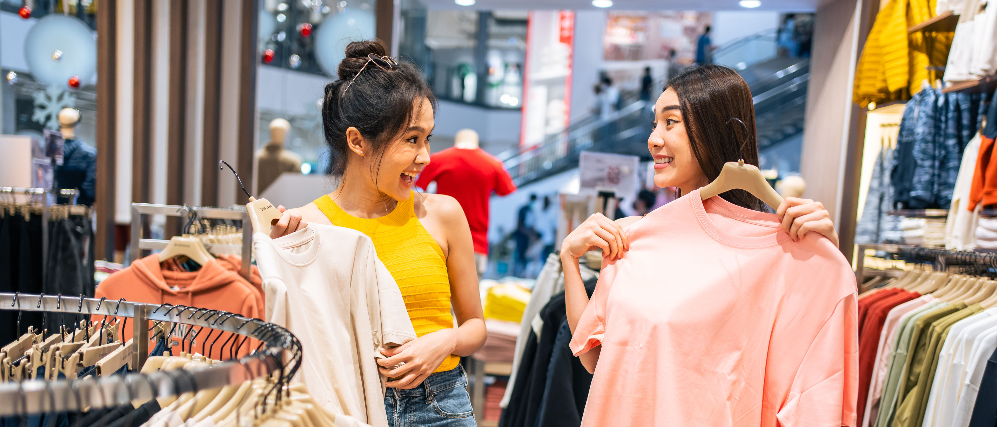 Two asian woman with dresses in hand