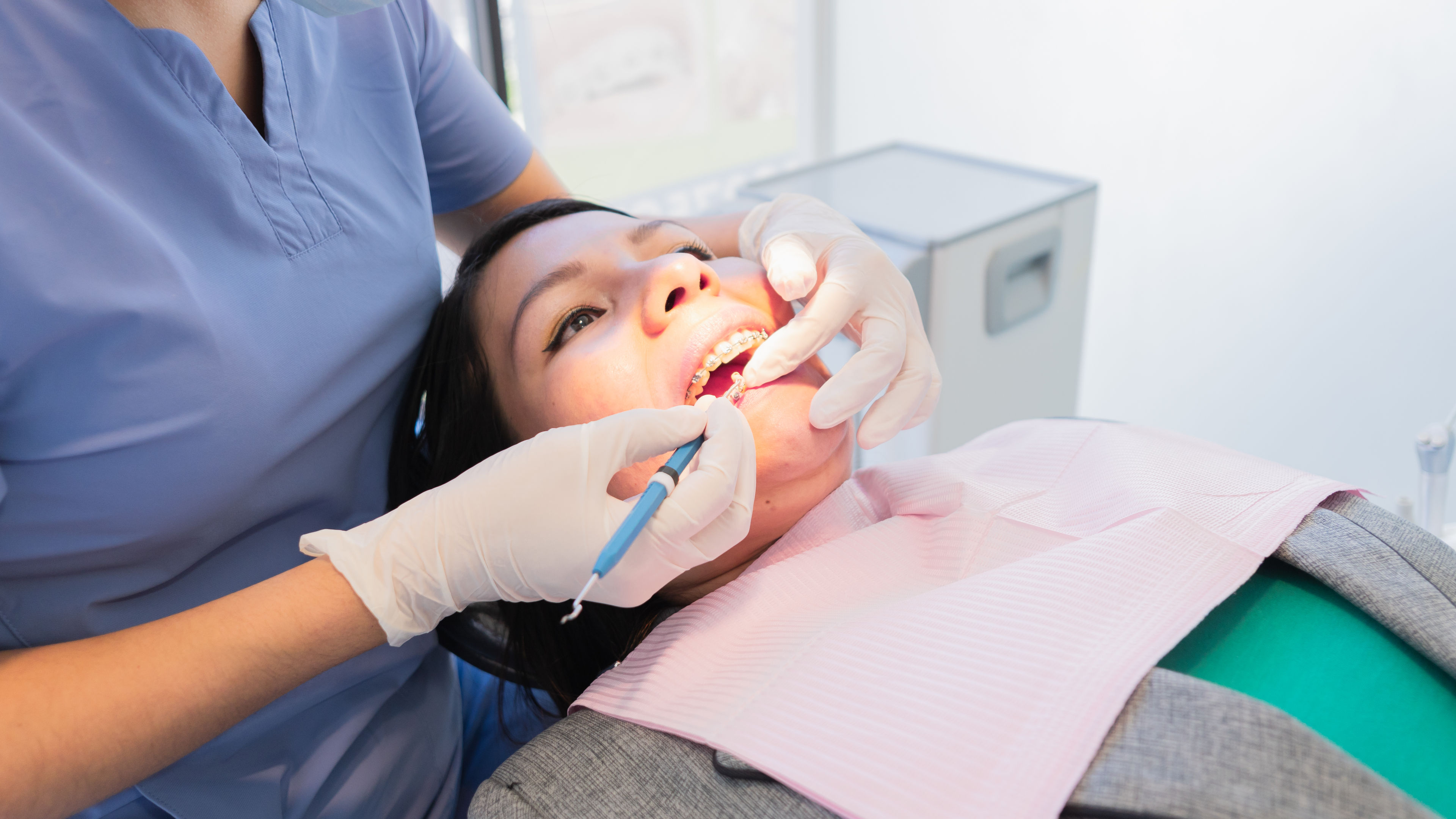 Young female dentist performed dental procedure to a female patient.