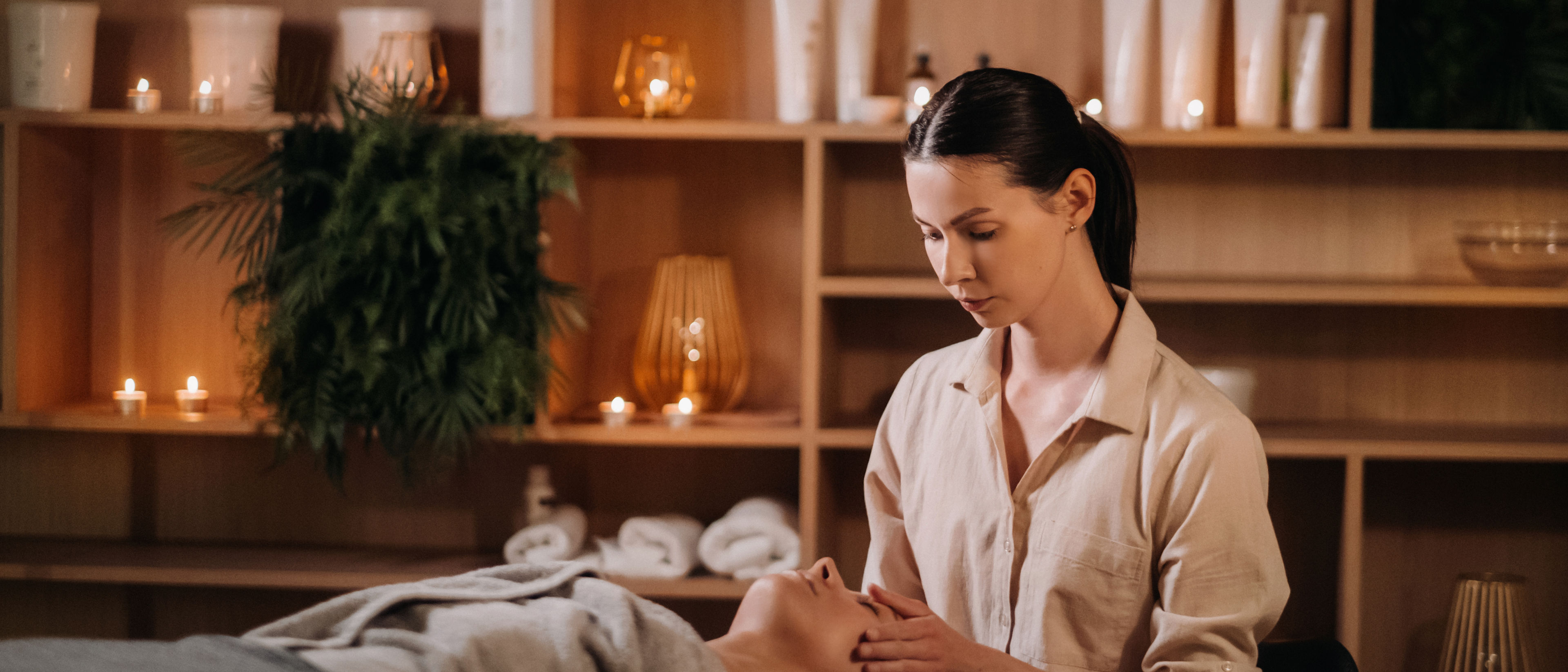 A cosmetologist girl does a facial and neck massage