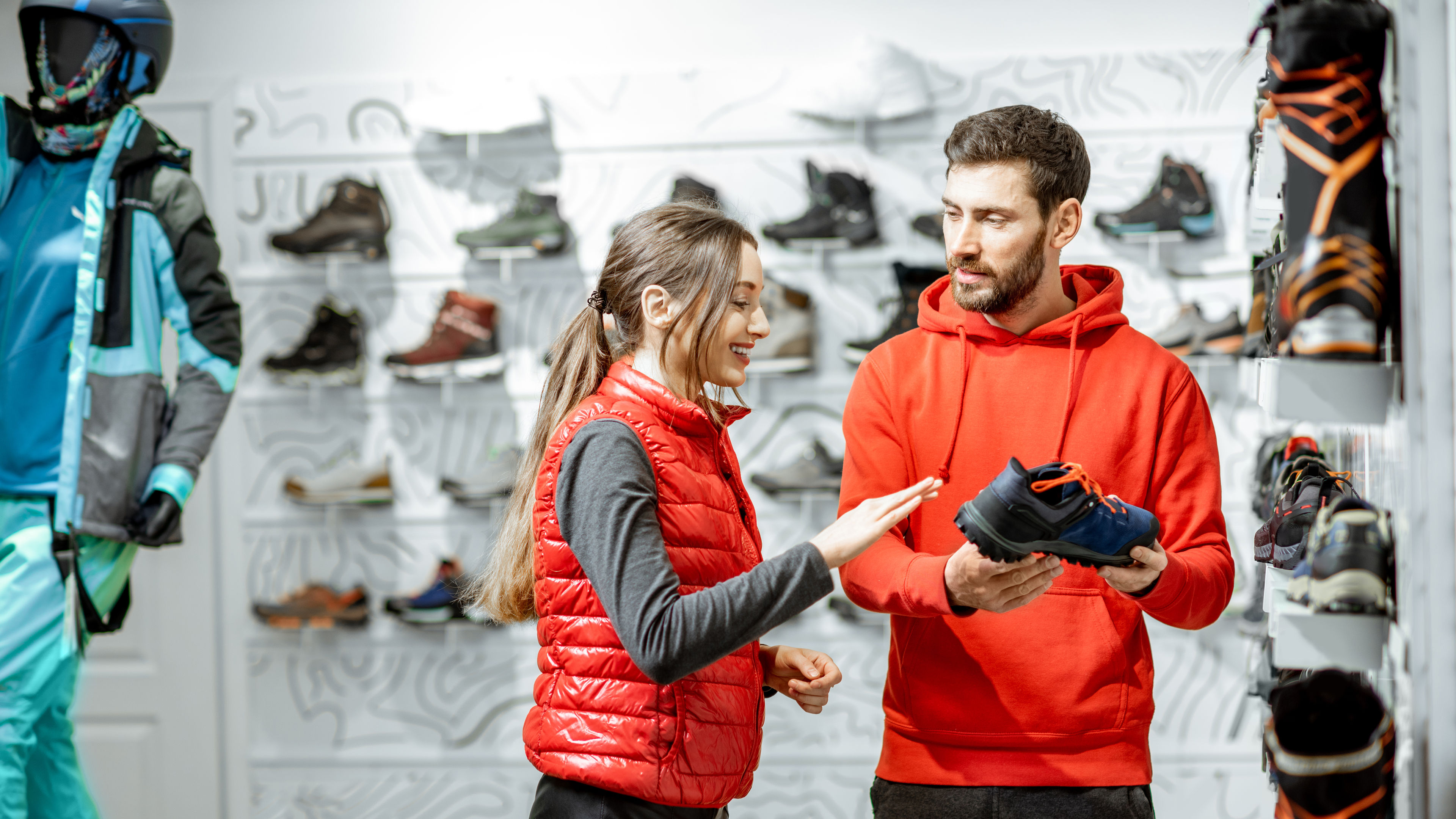 An Australian couple in red outfits shopping for shoes in a store