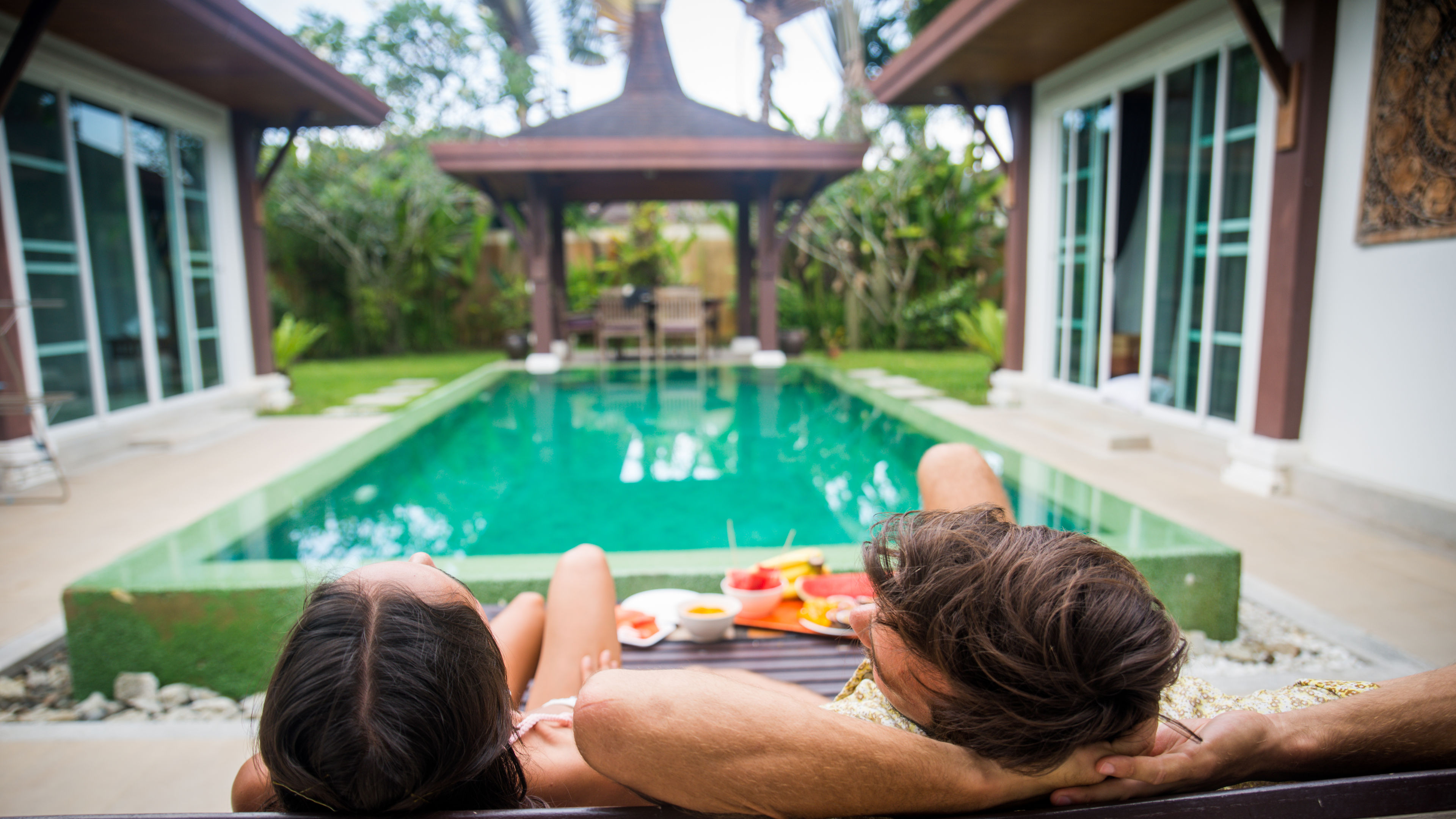  A couple of lovers is spending time in a beautiful villa with a swimming pool. 