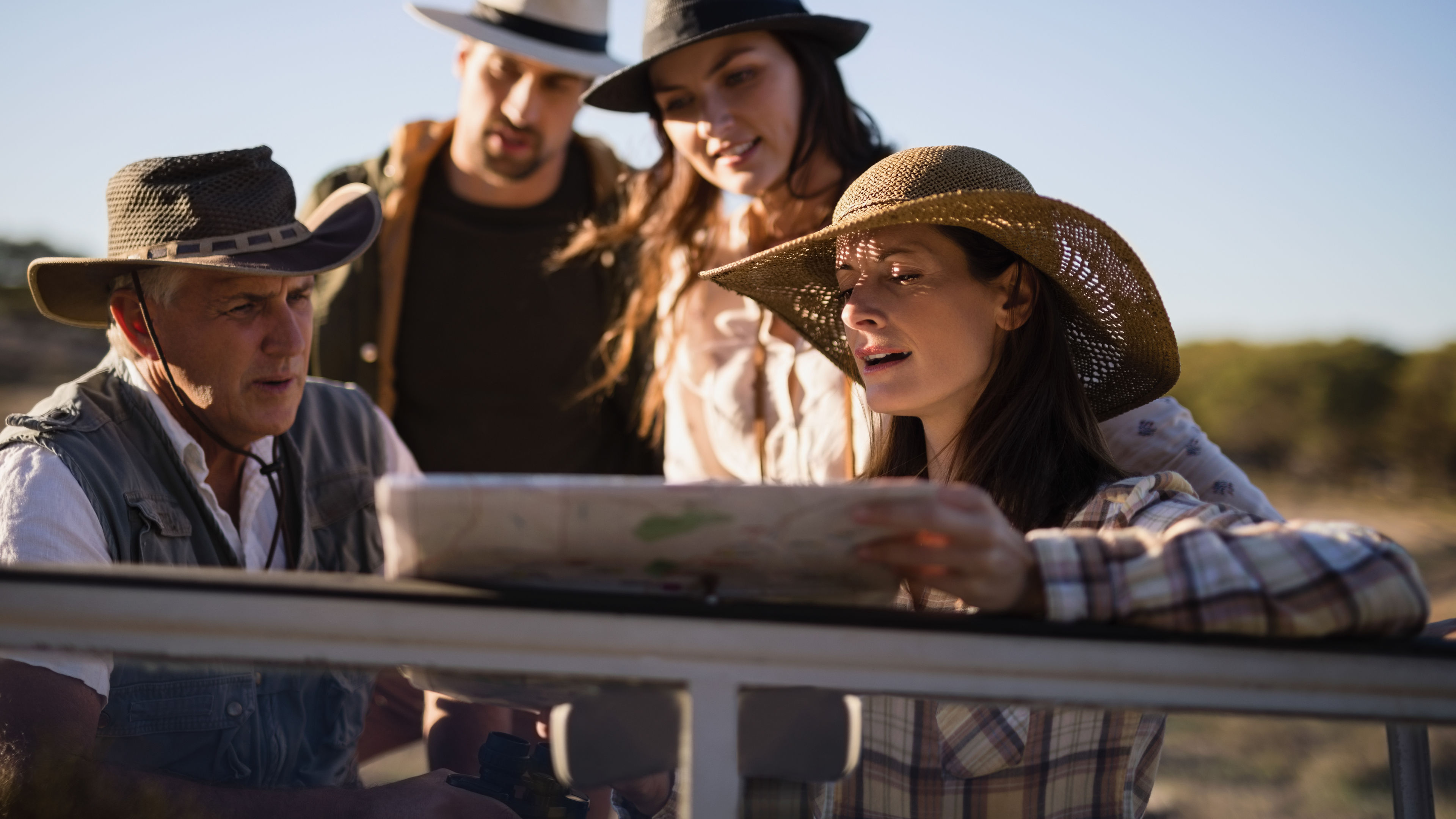 Friends looking at map in vehicle while travelling 