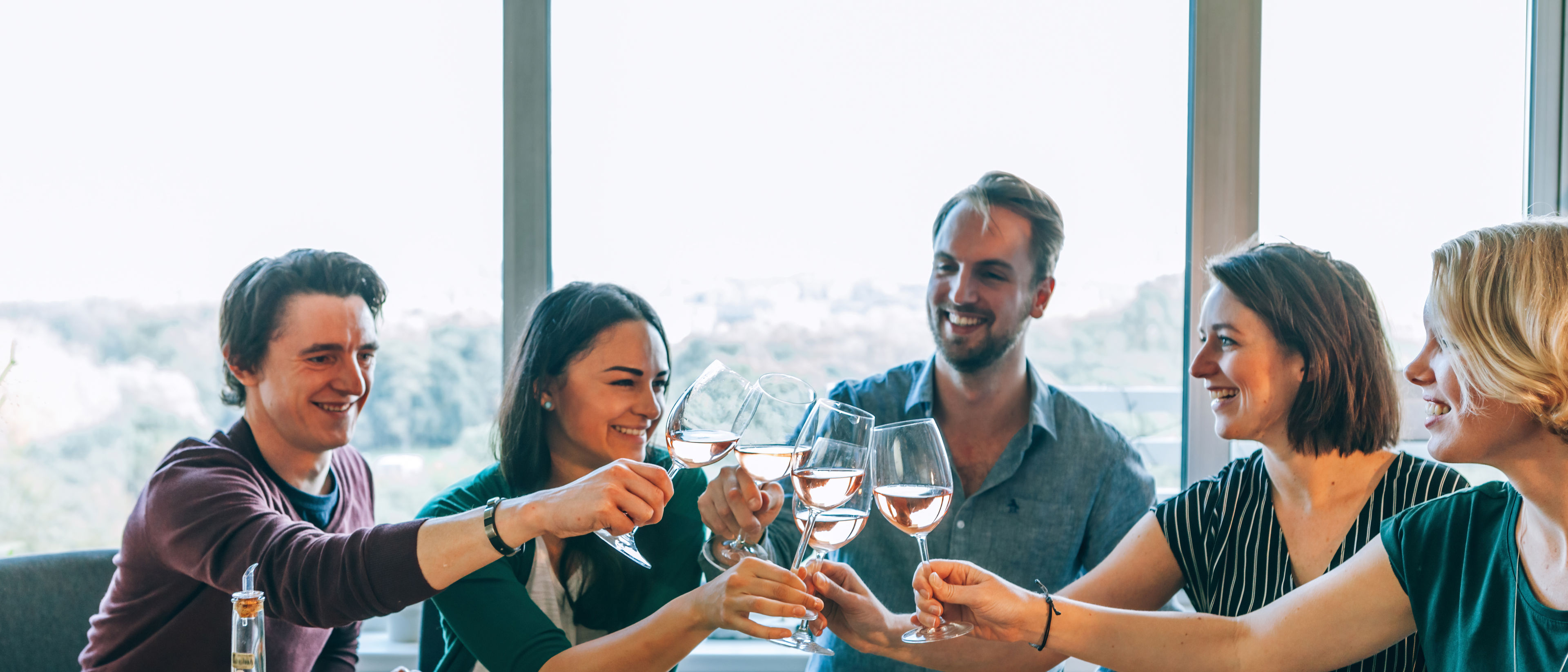 Friends are raising their wine glasses in a celebratory toast.