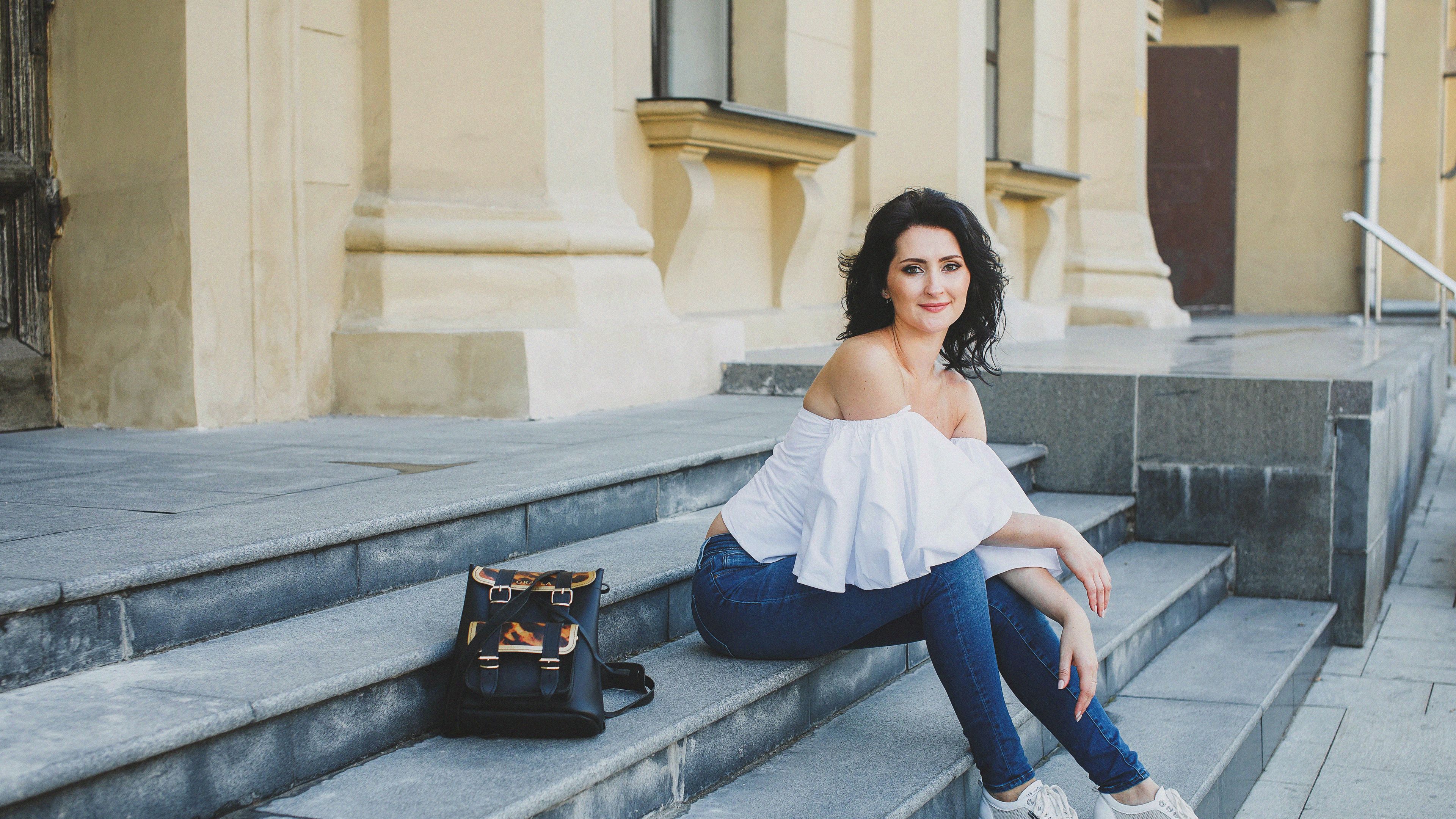 A girl is sitting peacefully on the steps. 
