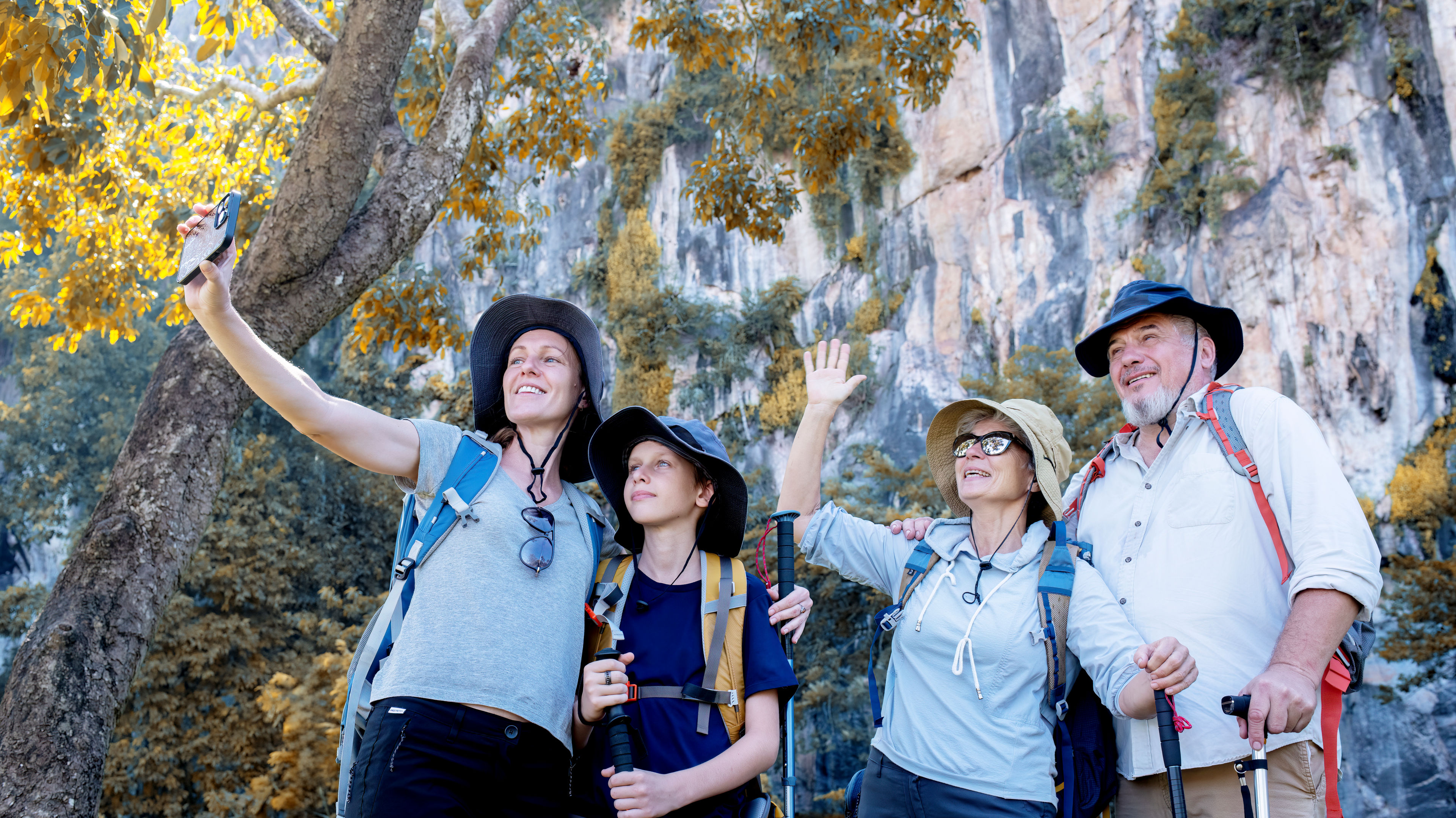 Hikers or explorers happy on journey carrying backpack, trekking poles looks into selfie smartphone 