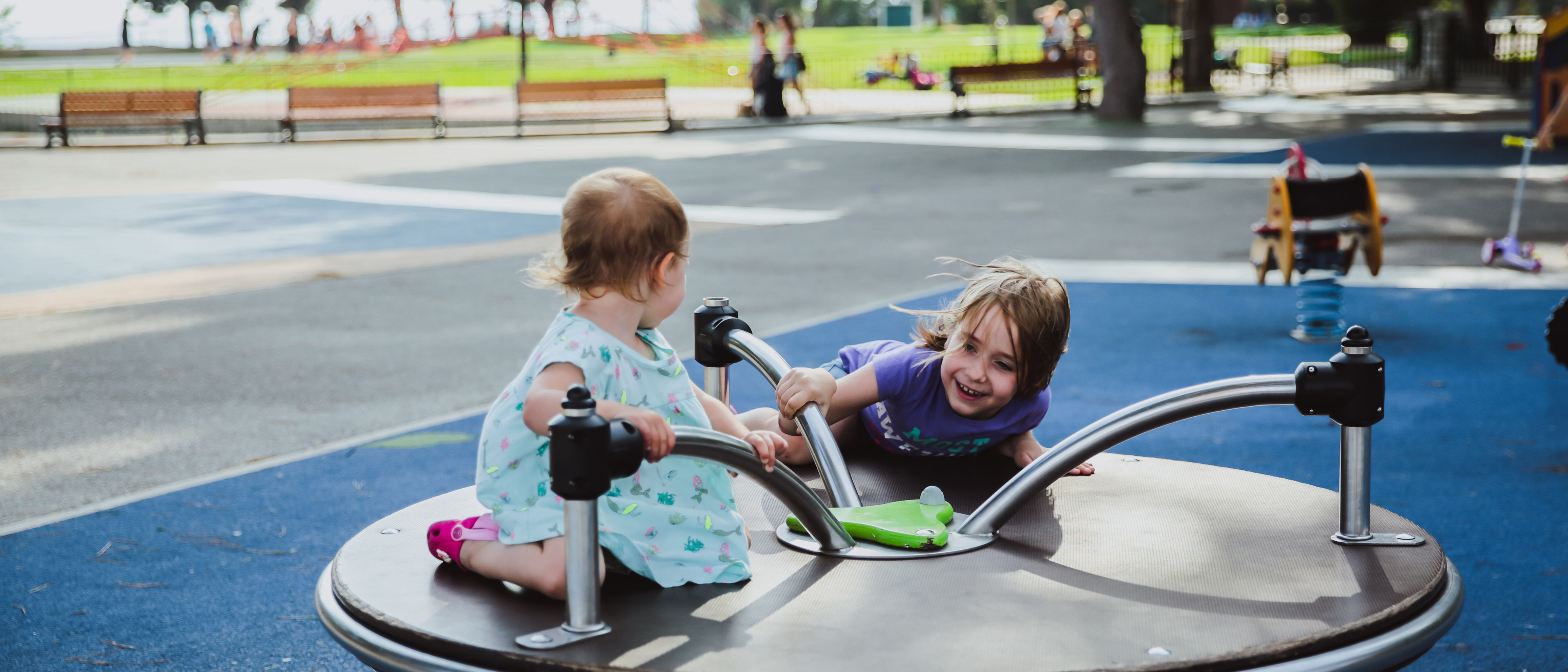 Two happy sisters playing on the children's playground