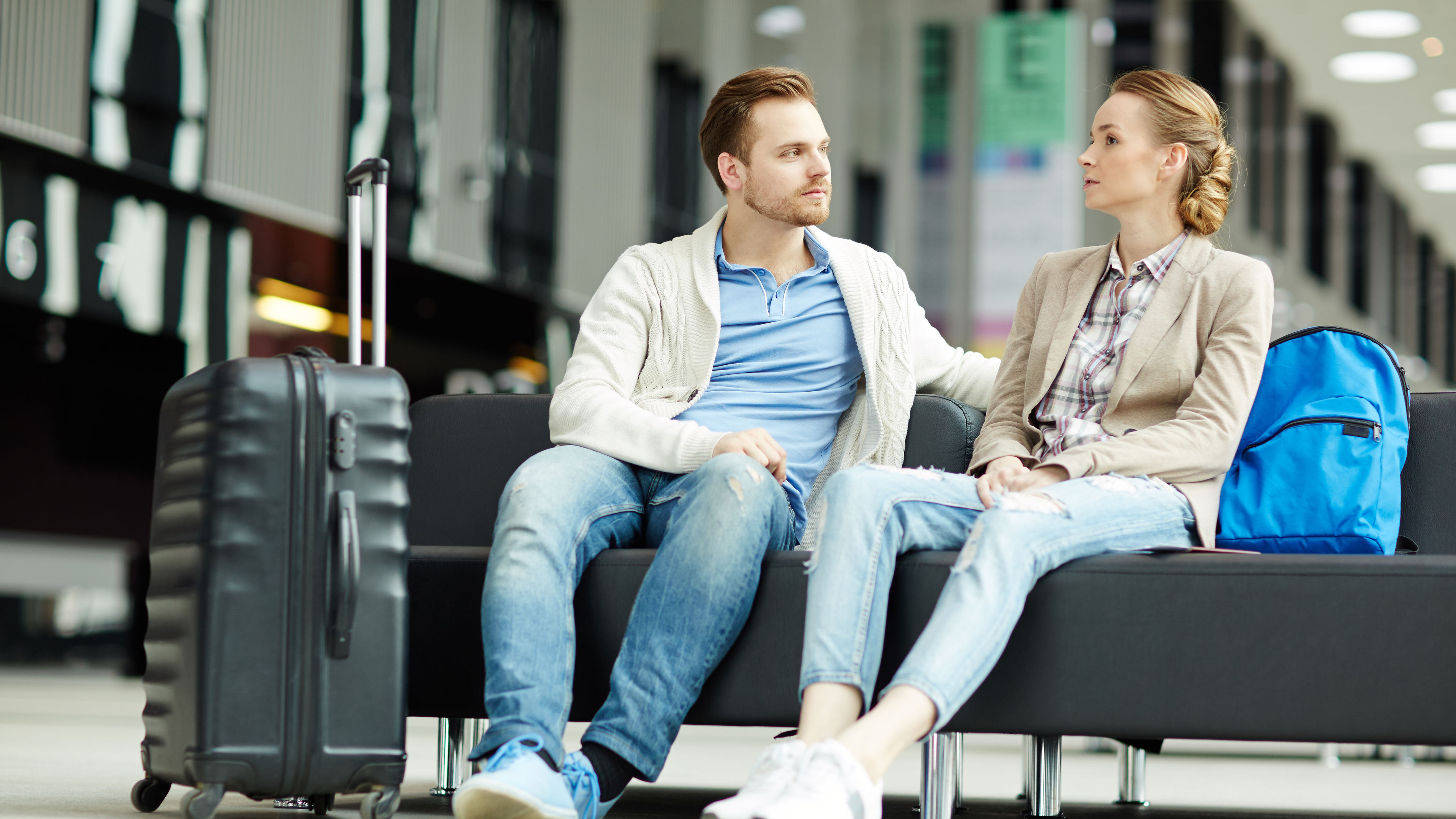 Young couple sitting in airport lounge