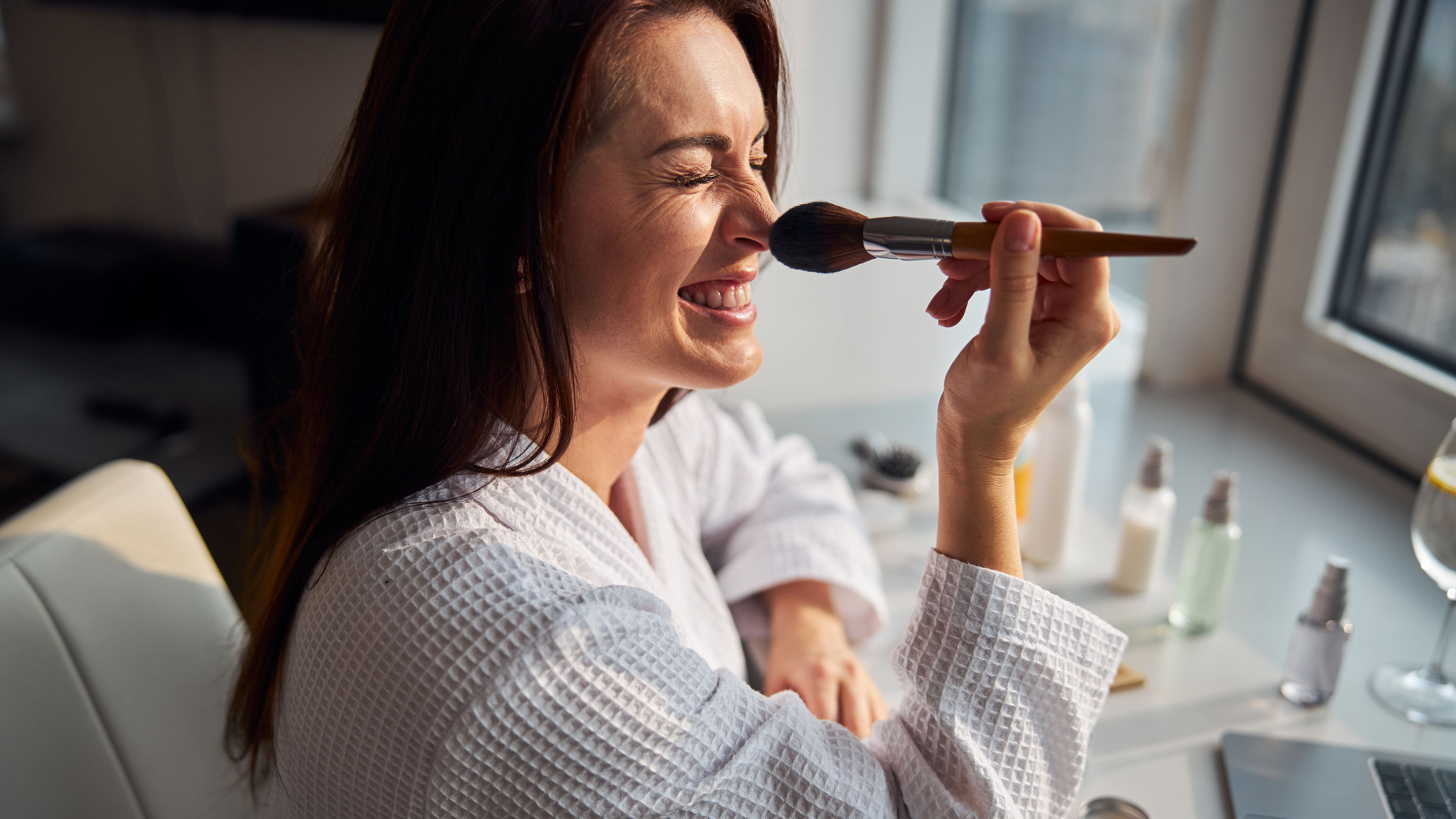 Young female using brush for makeup 