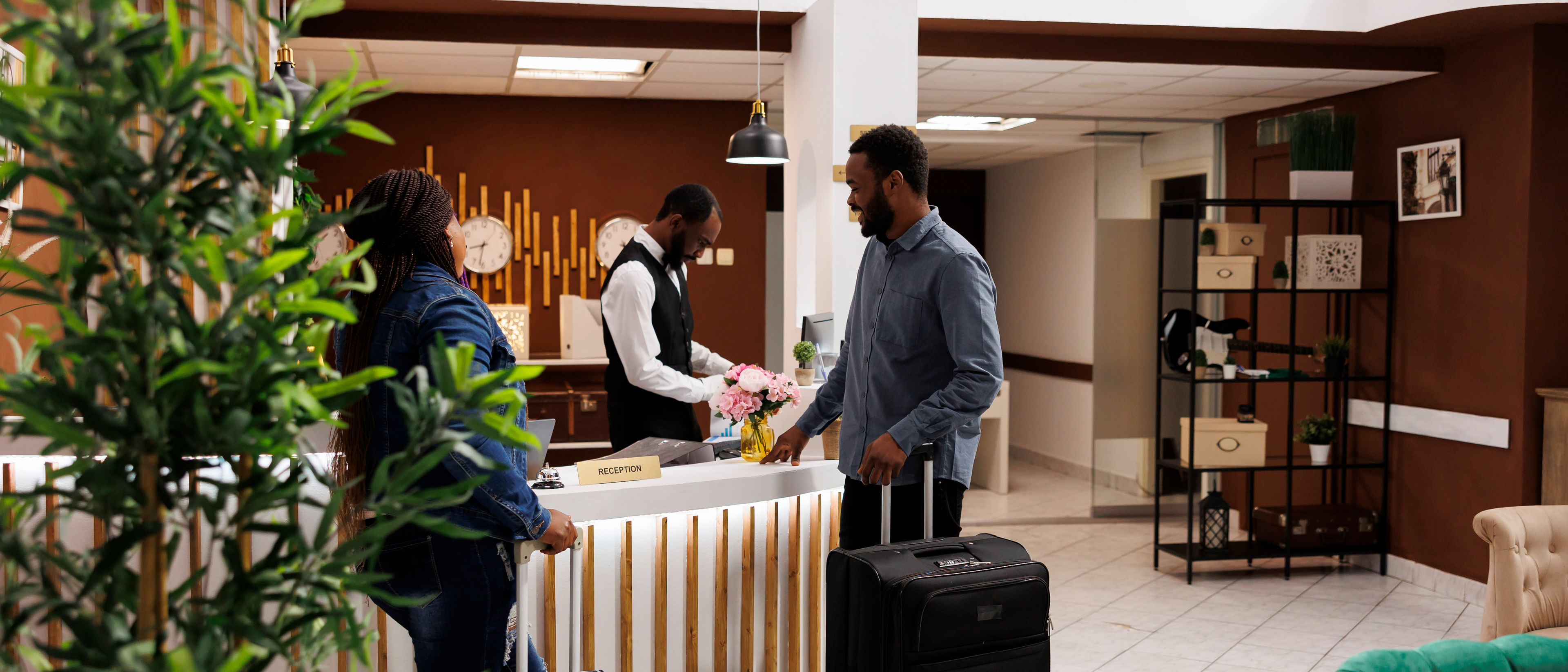 couple standing at hotel front desk with luggage