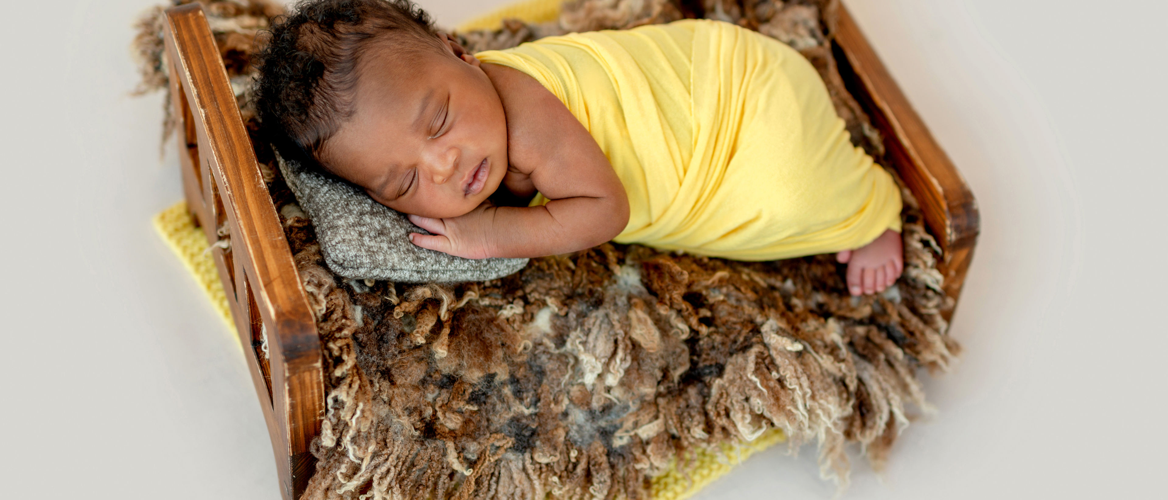 Newborn sleeping in wooden cradle