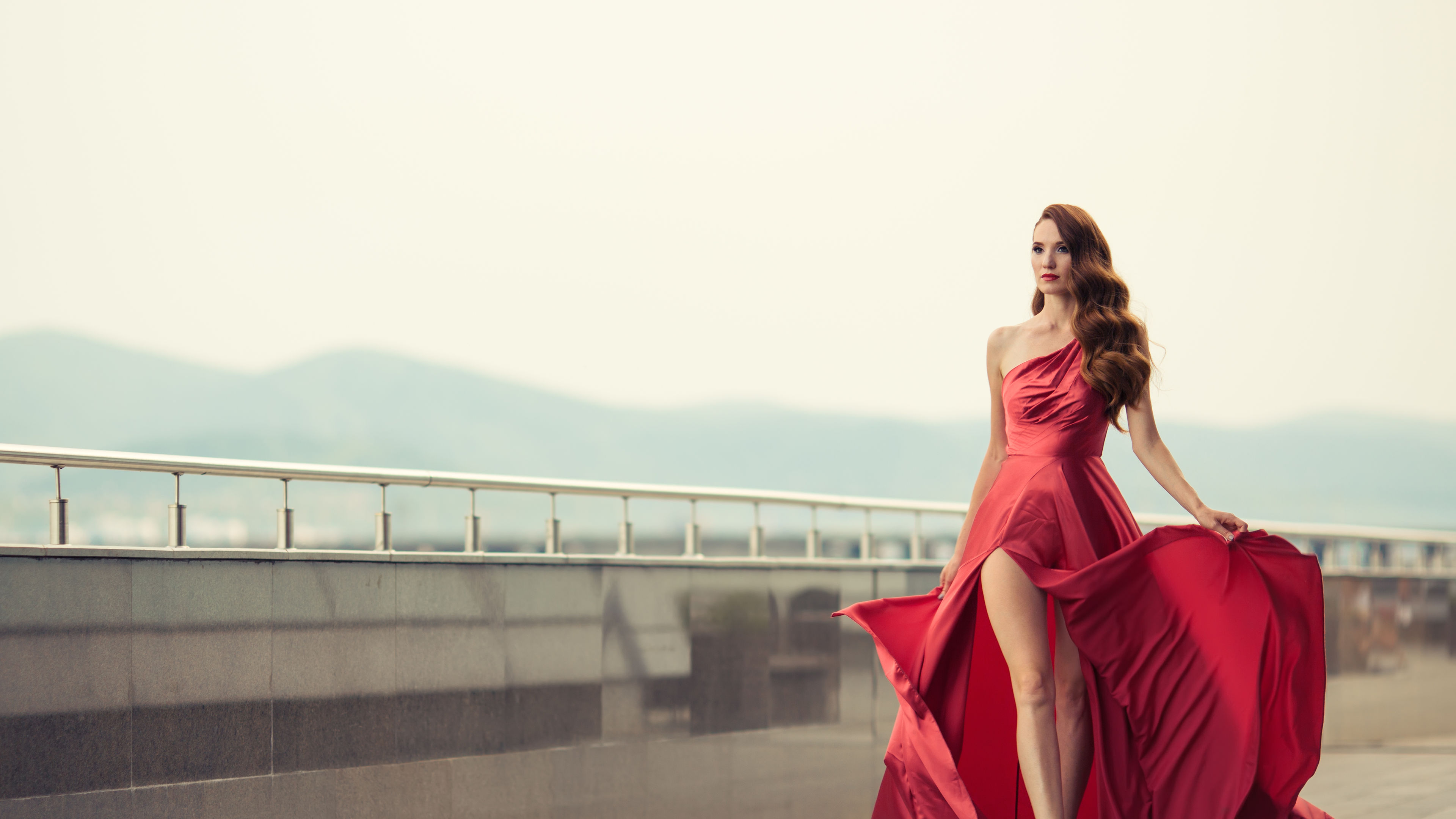 Beautiful Woman In Red Fluttering Dress. Urban Background. 