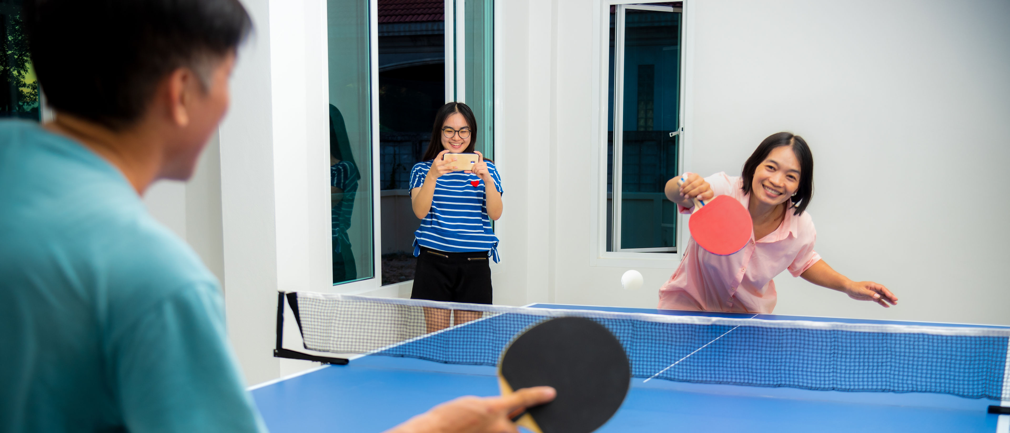 Couple fun playing table tennis indoor together.