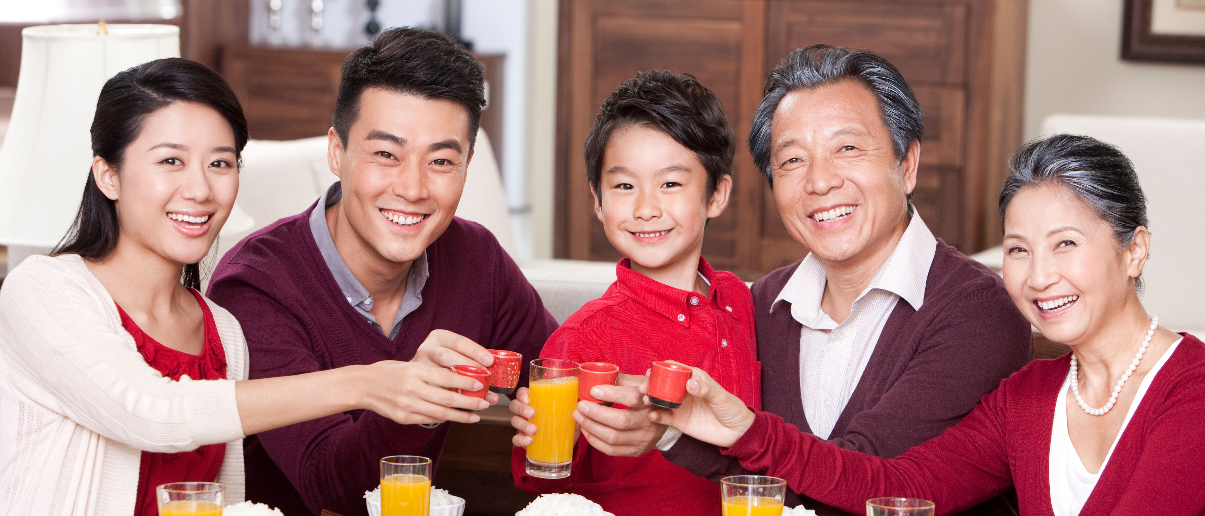 Family toasting at dinner table.