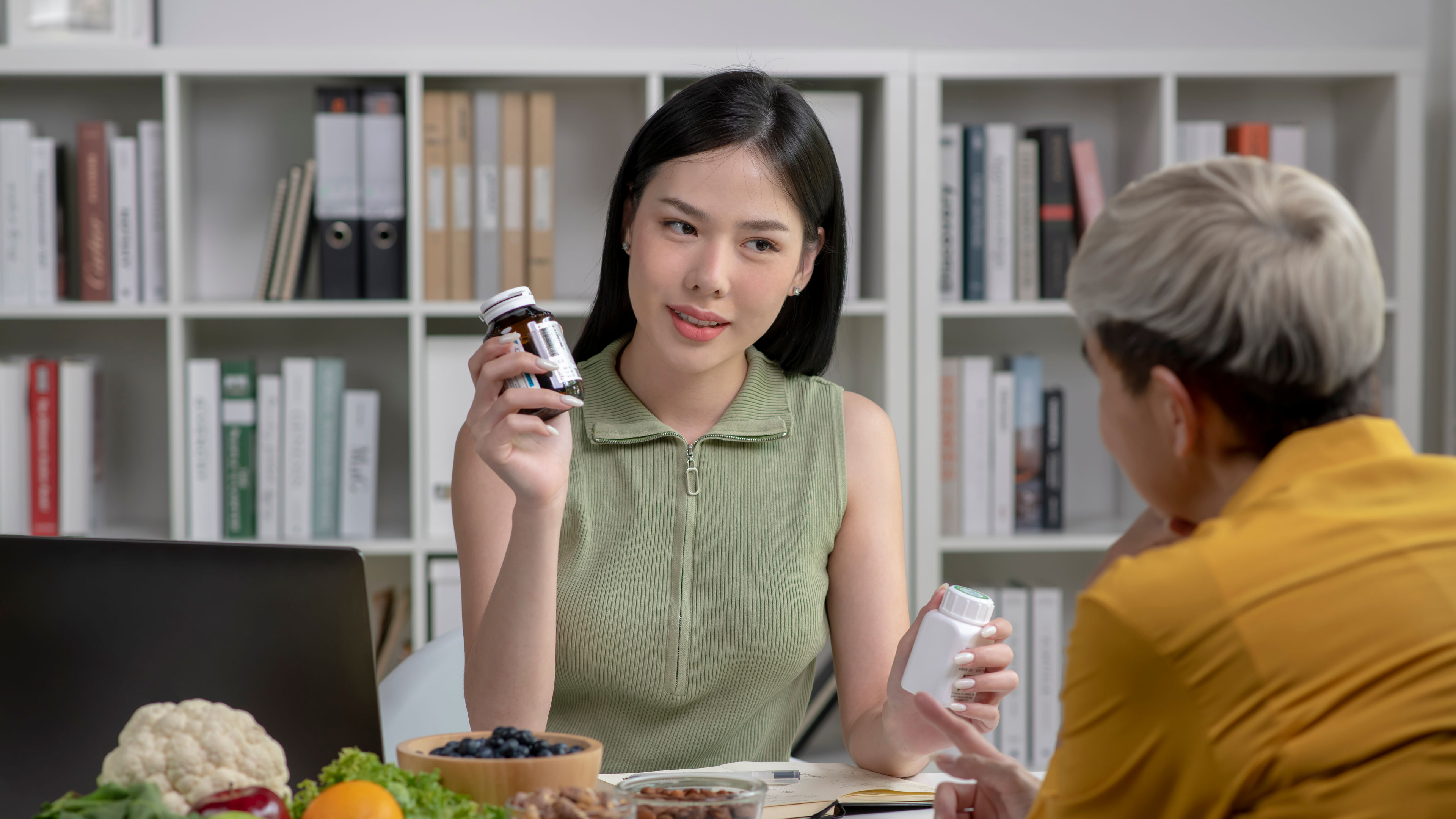  Nutritionist with woman client talking about meal plan and healthy products during a medical consultation in the office 