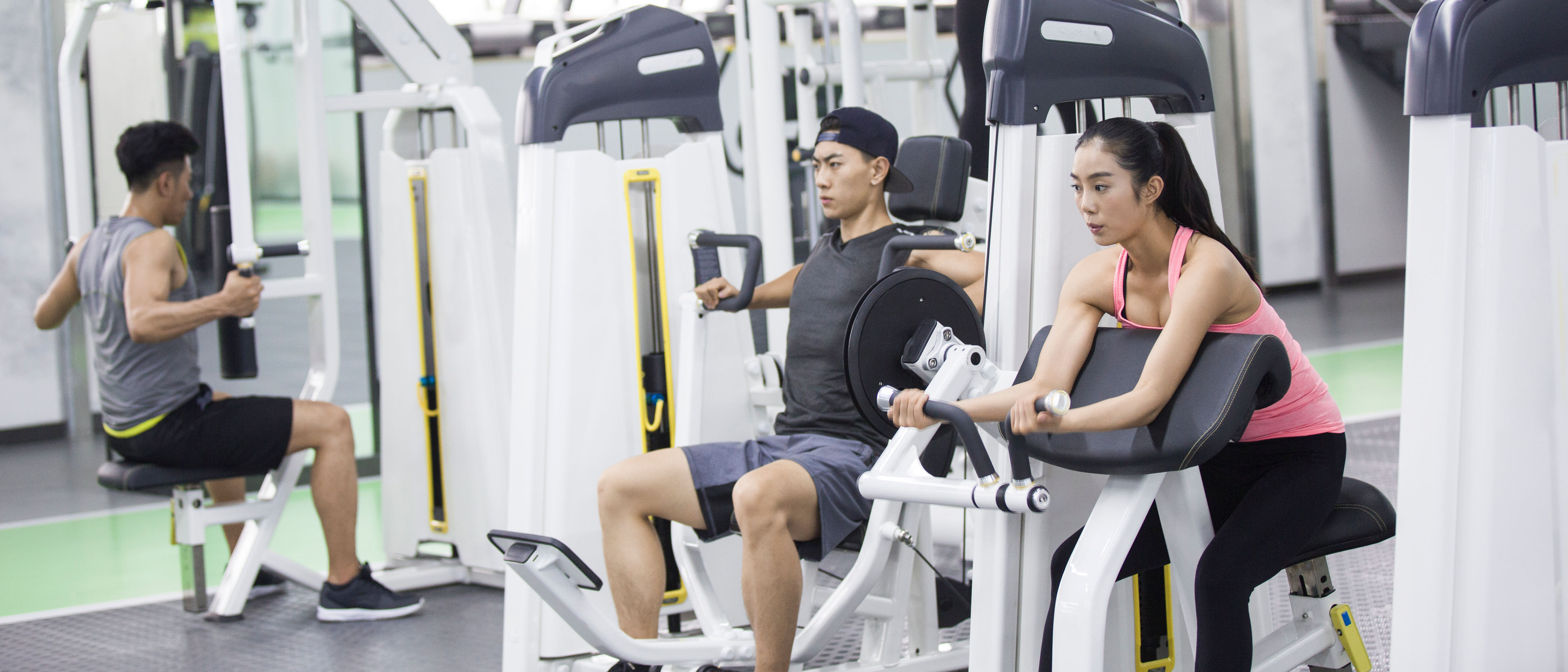 Young adult using exercise machine at gym.