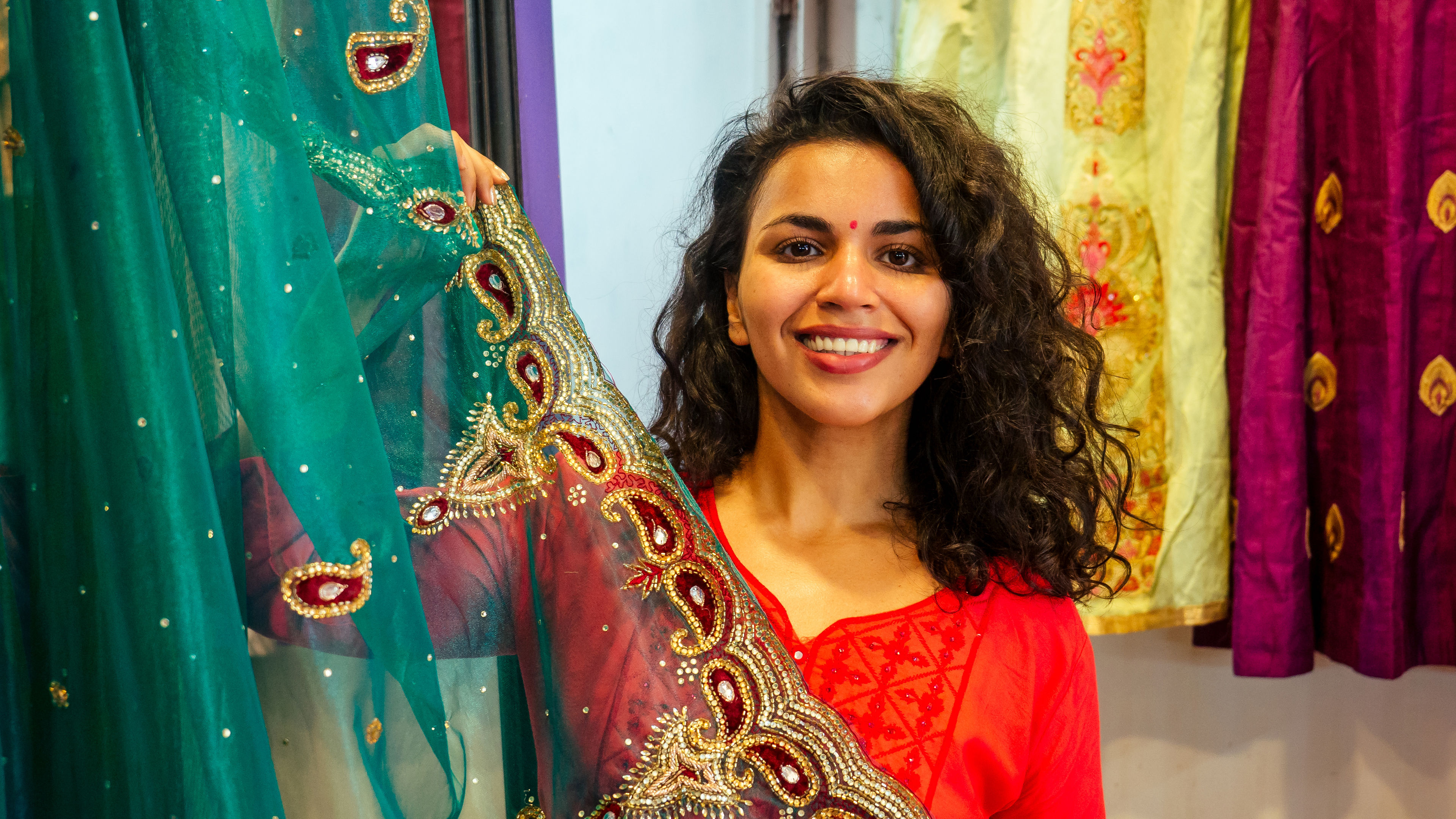 An Indian women in orange dress shopping saree.