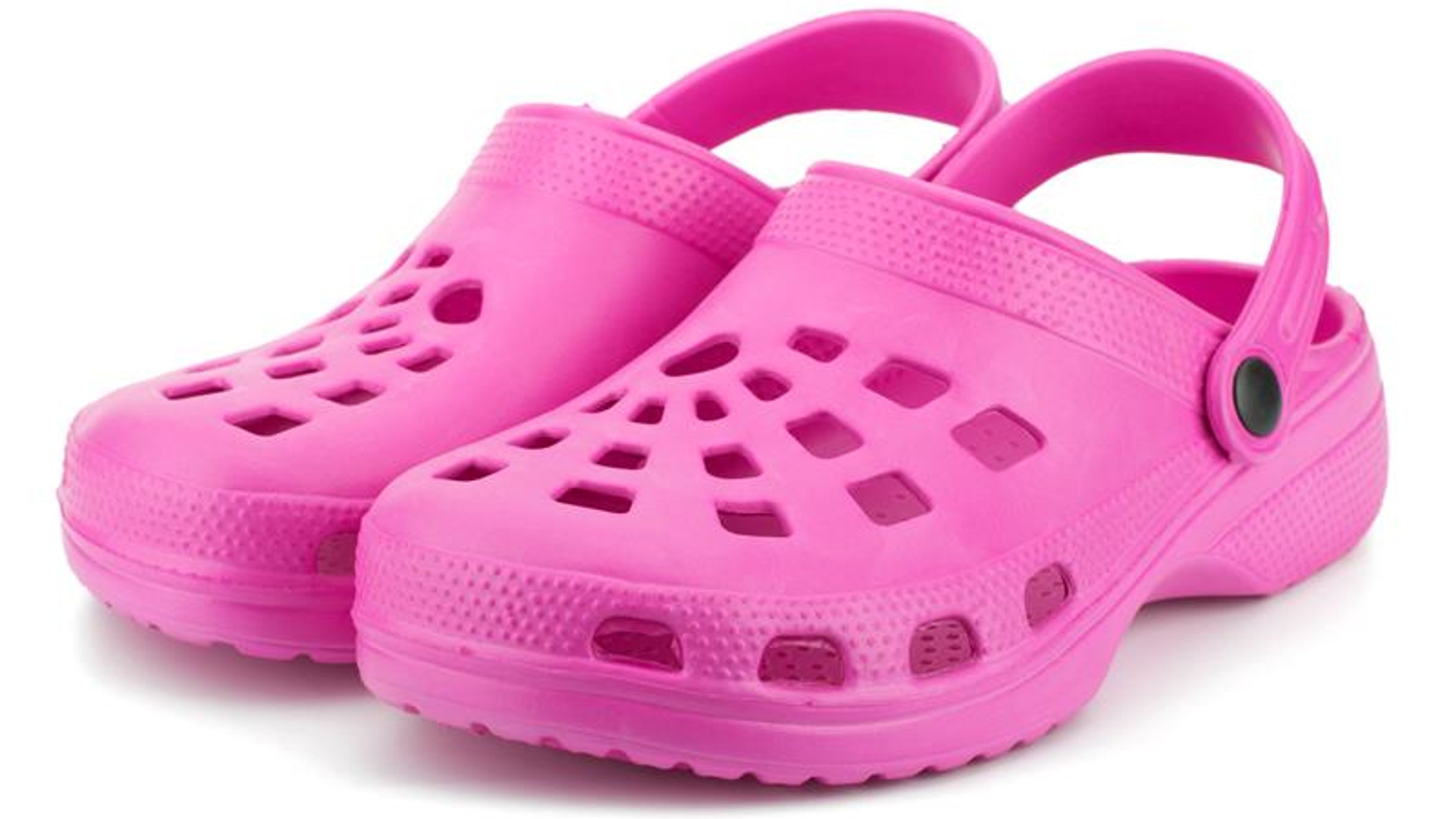 A pair of pink rubber sandals placed on a white background.
