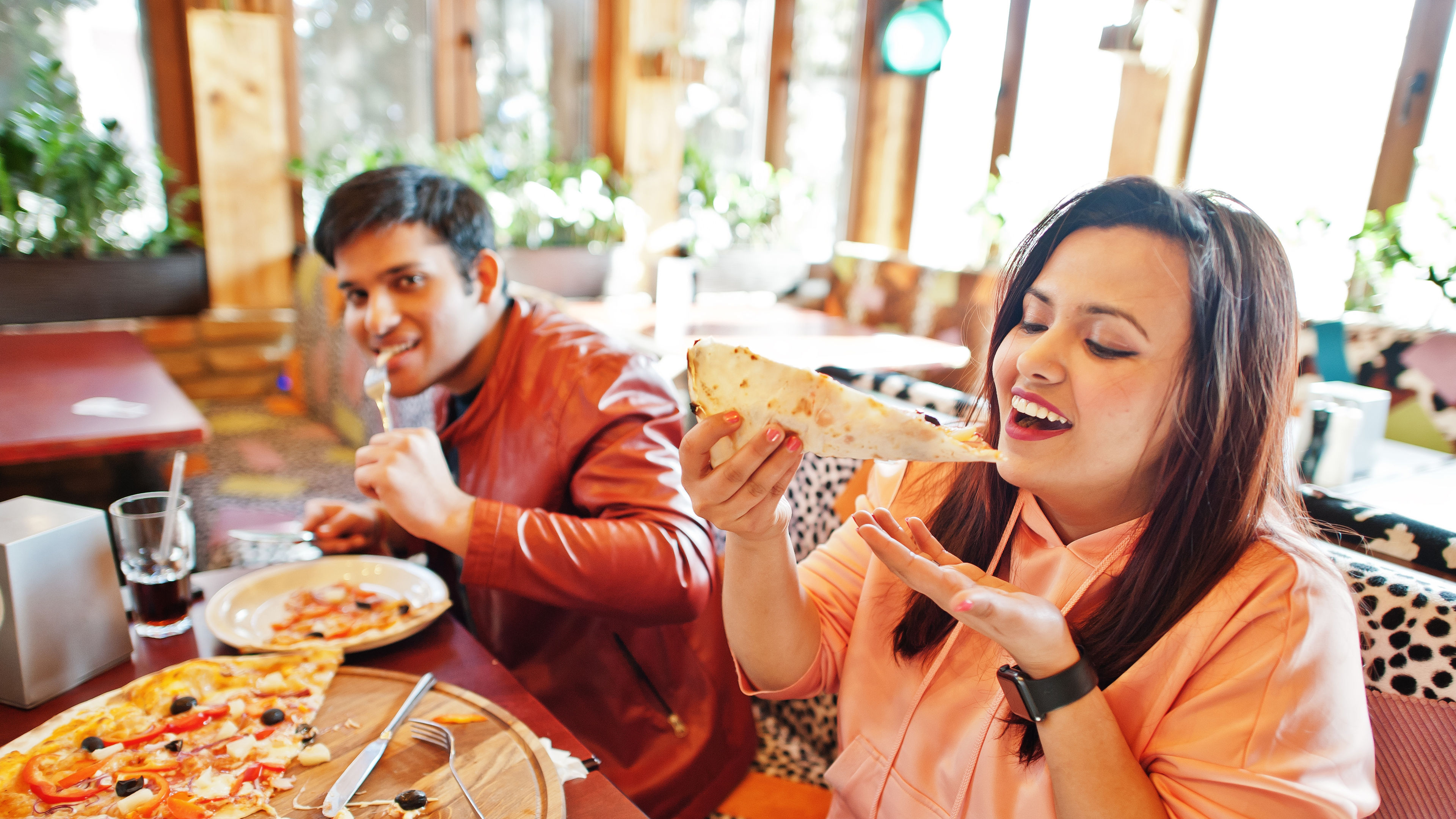 Young Indian people enjoying a large pizza.