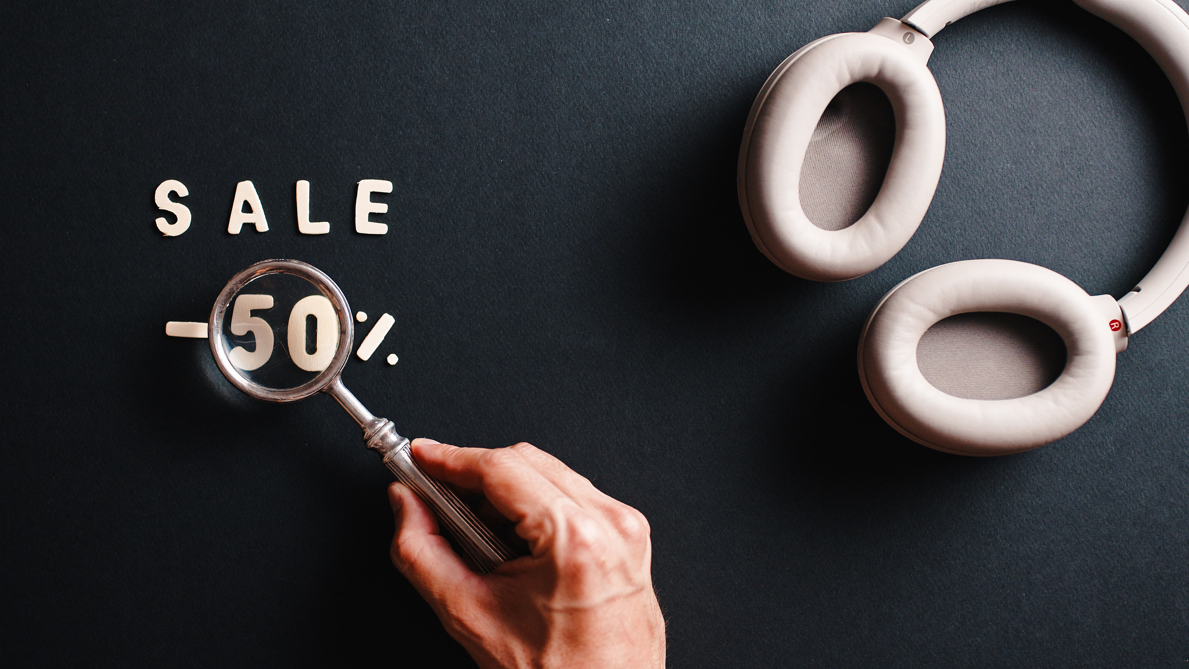 A vibrant 50% discount banner features a pair of headphones, highlighting a great sale on audio gear. 
