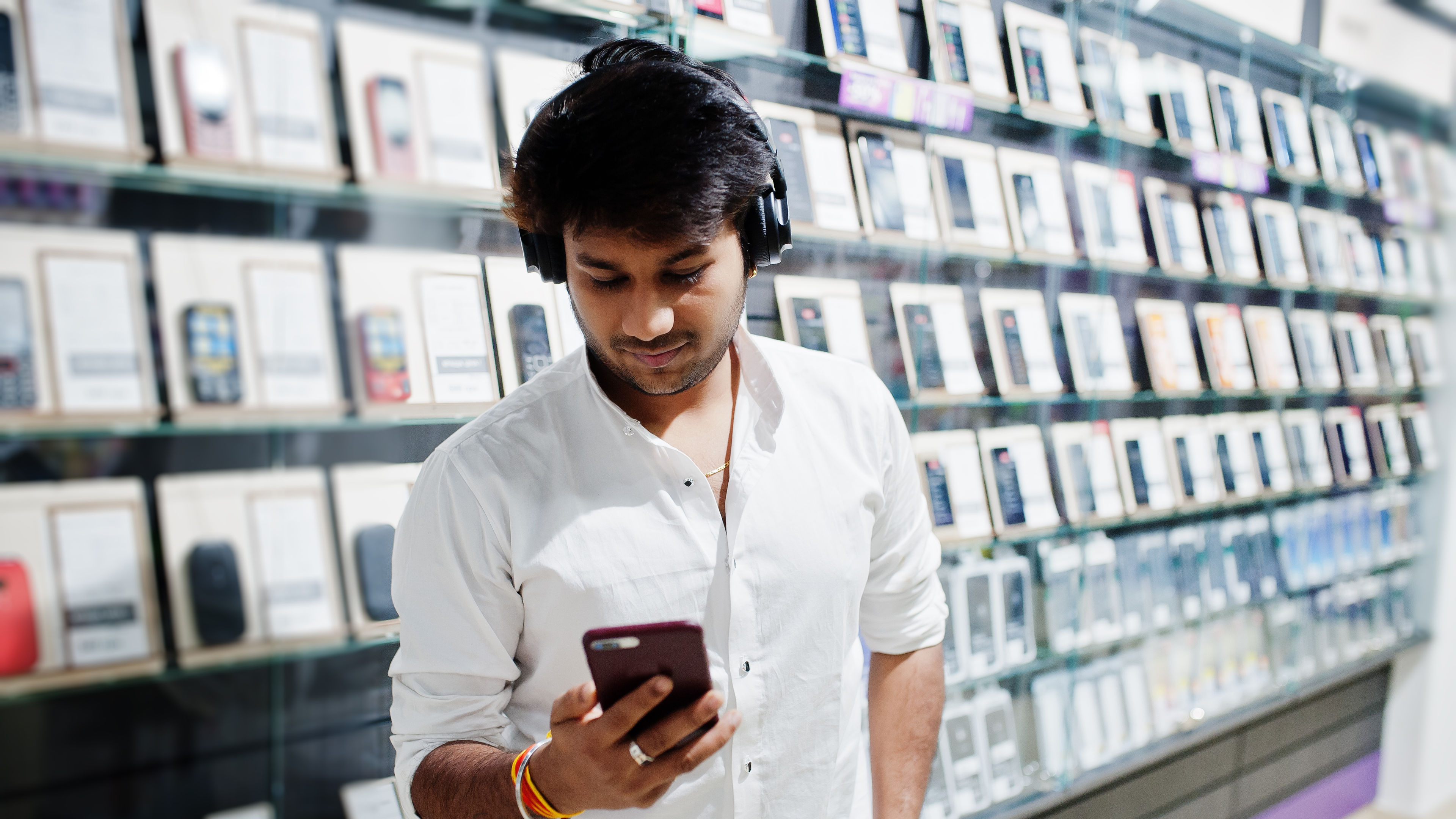 A cellphone shop with a man holding a mobile in hand 