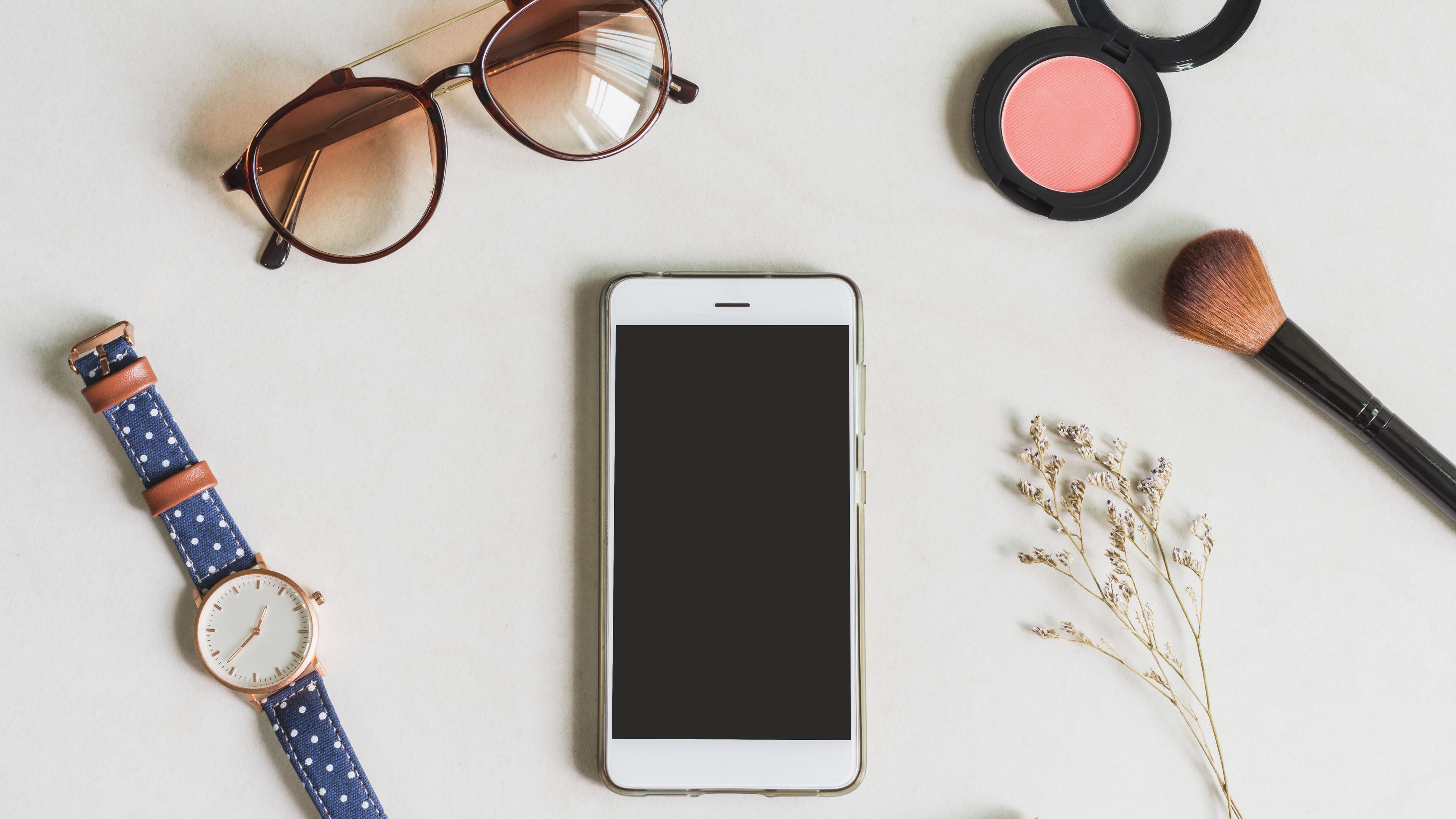 All essentials like beauty products, tech essentials etc on a table 