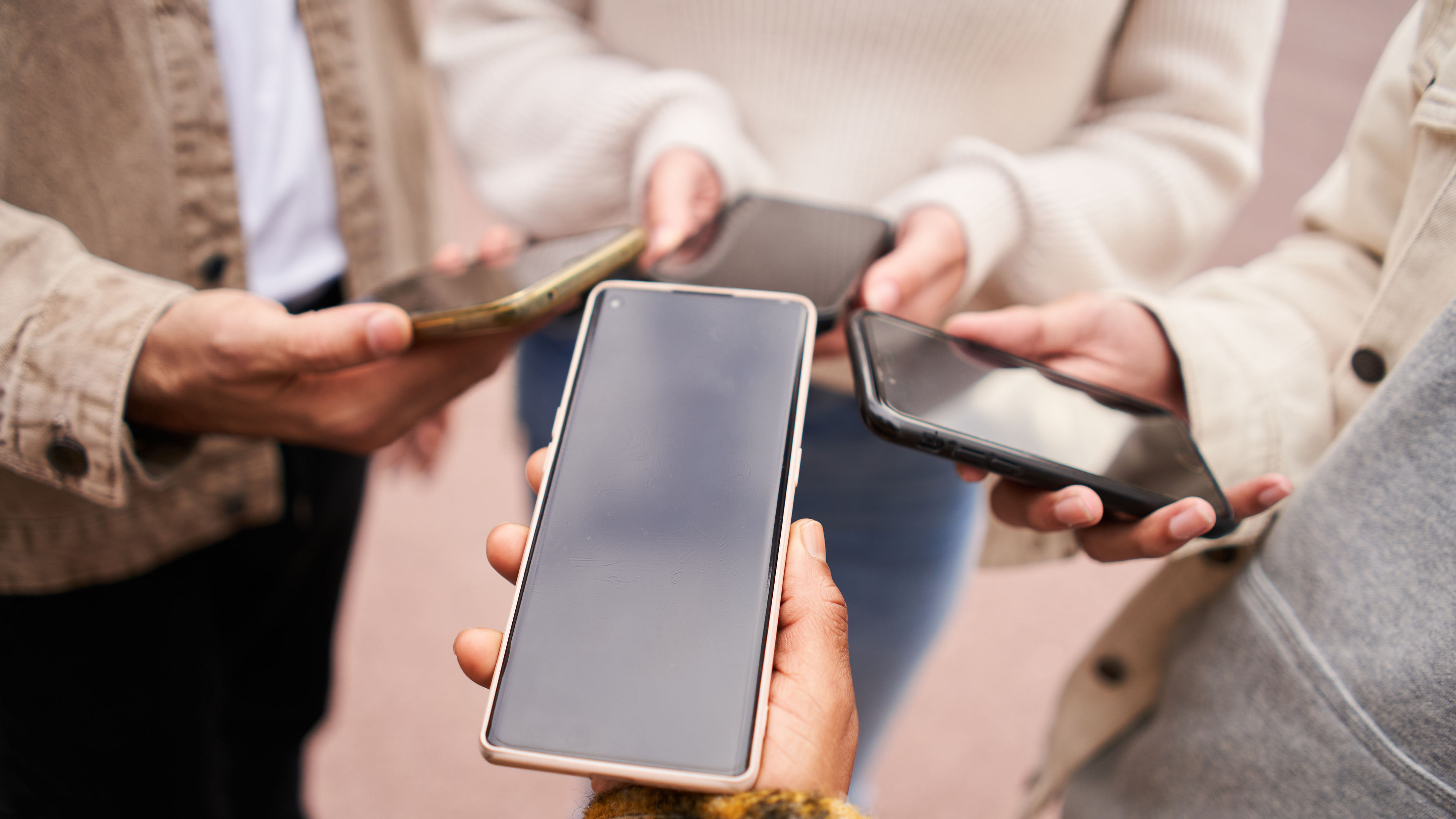 Close up of people hands sharing content on social media network with smartphone. 