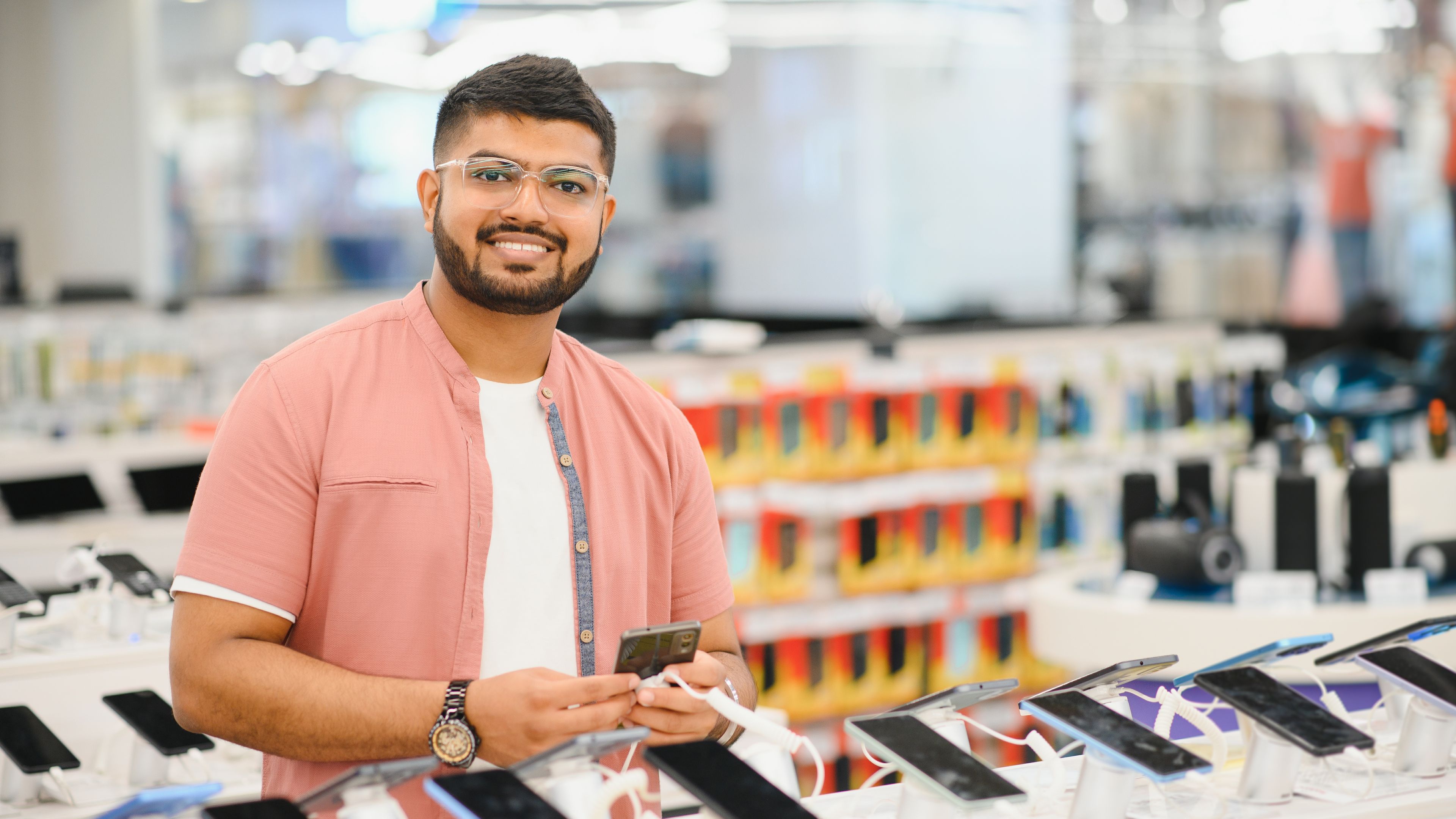 handsome young man buying new mobile in the electronic shop. 