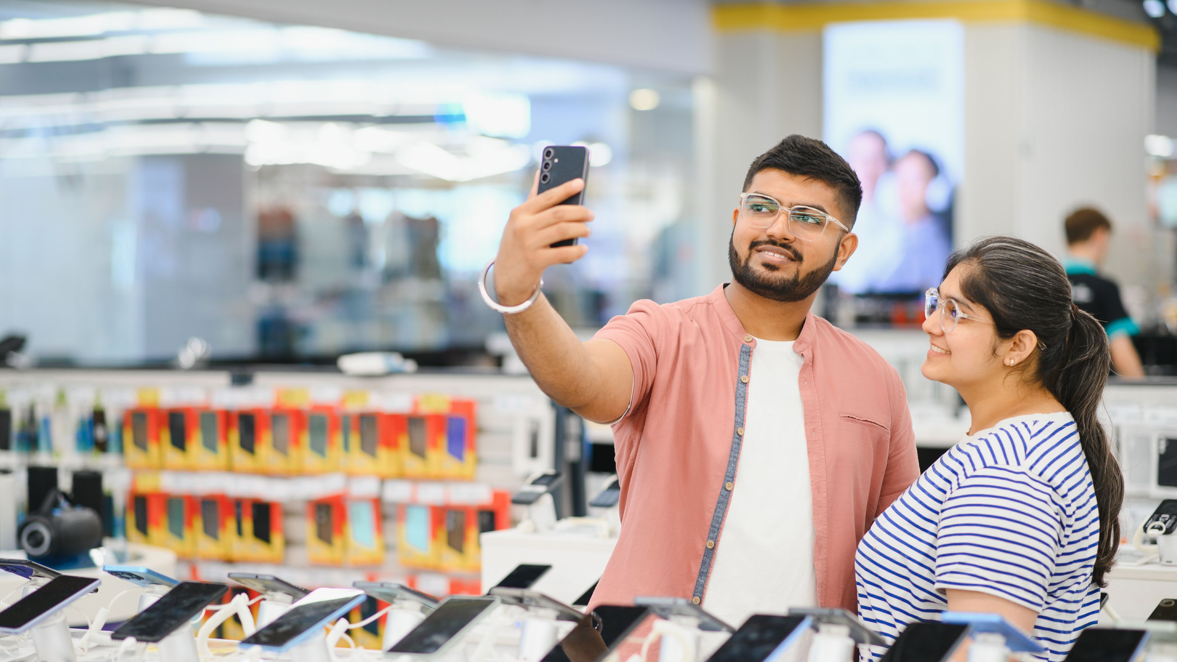 Indian couple looking for smartphone instore