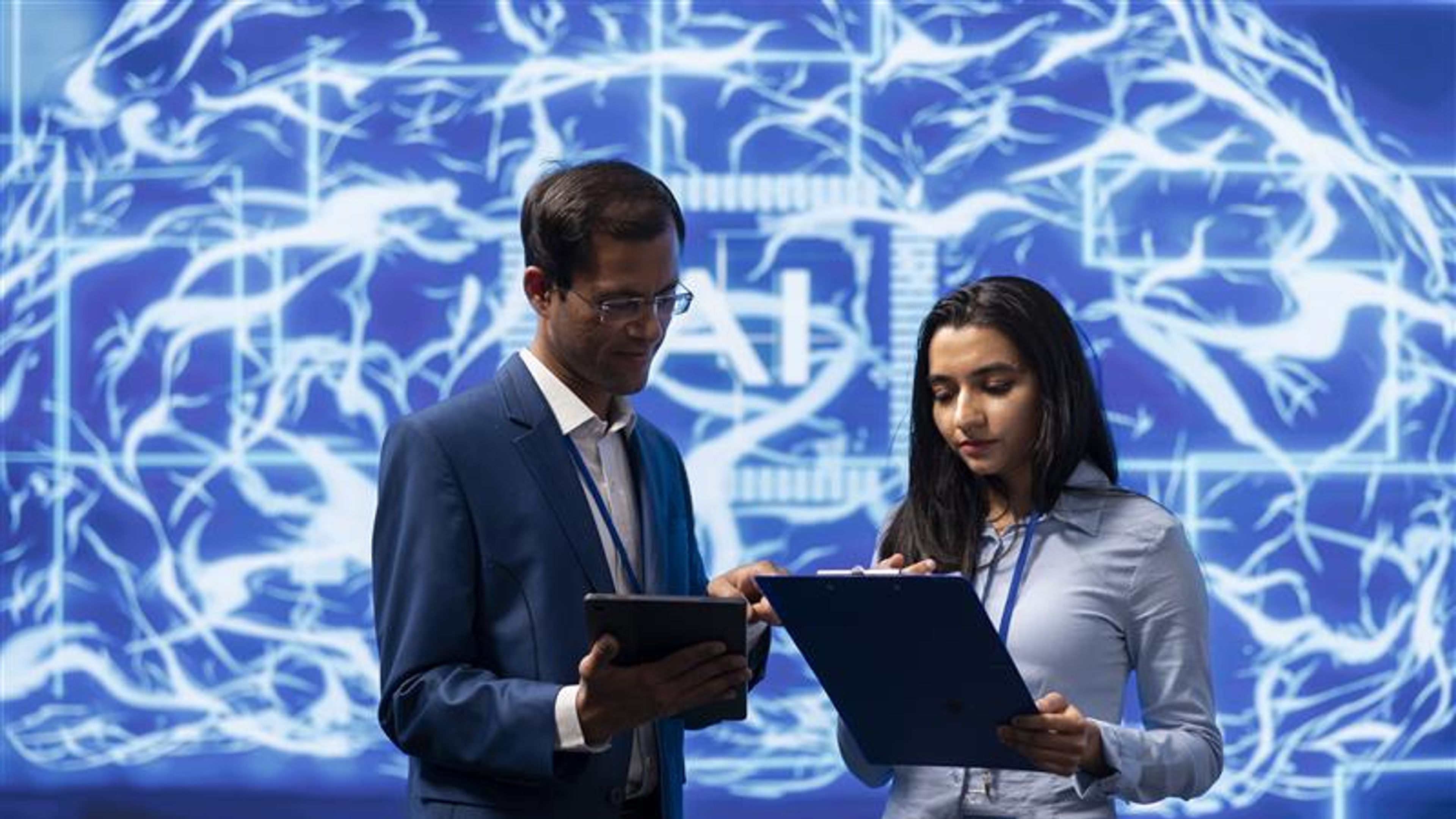 IT department coworkers solving tasks on laptop and tablet, running artificial intelligence programming scripts.  