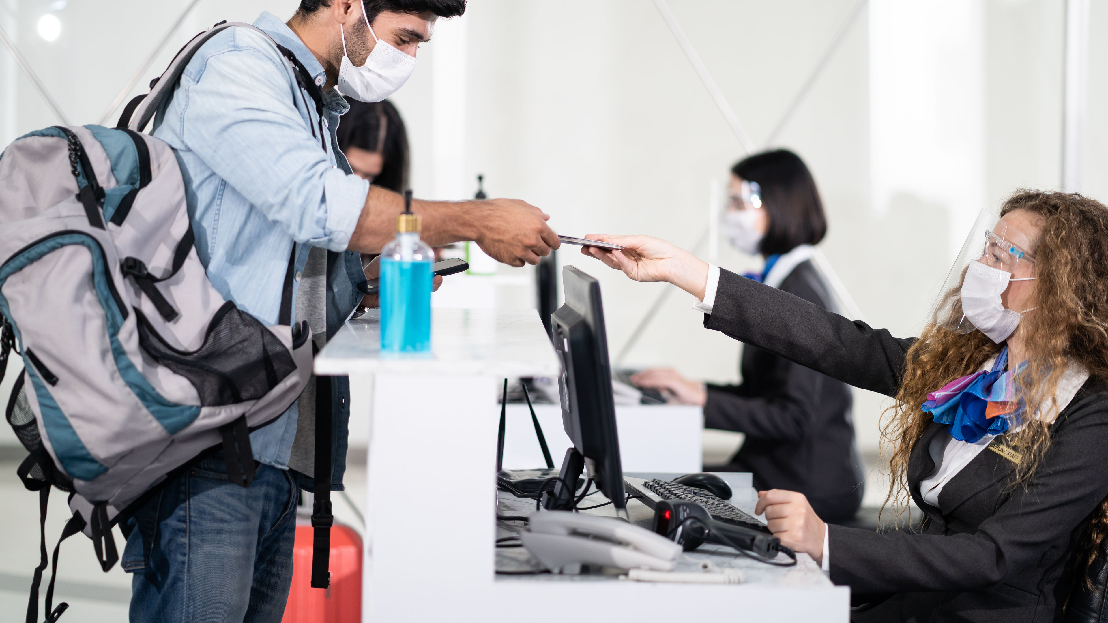 Male traveler give passport to female officer at airline check in counter 