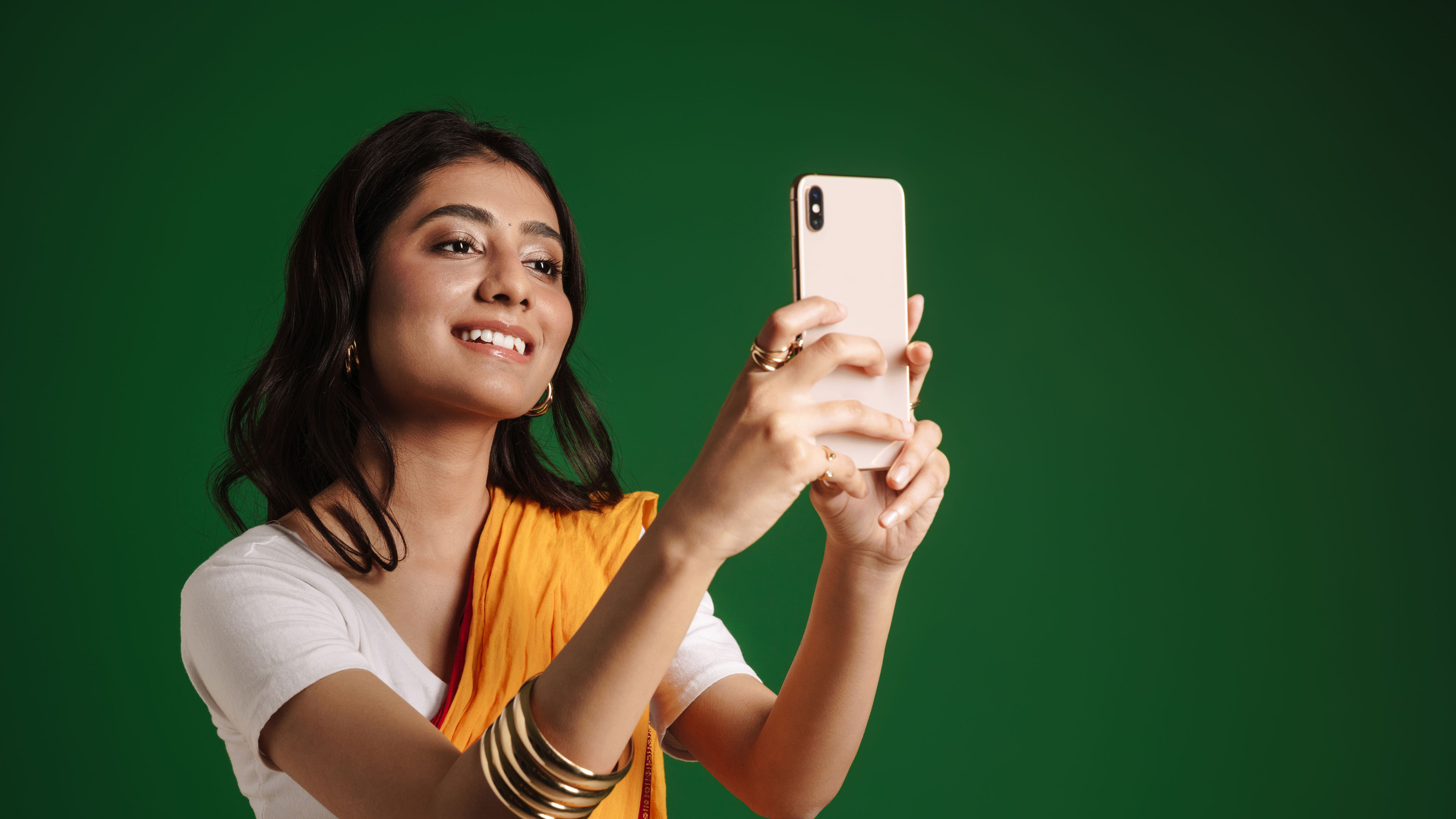 Young indian woman wearing sari taking selfie on mobile phone 