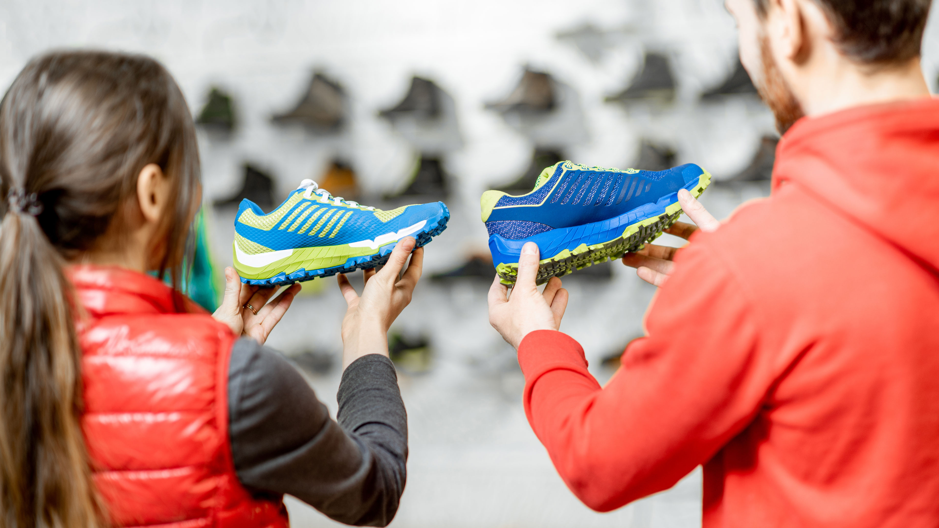 Couple holding shoes on hand.