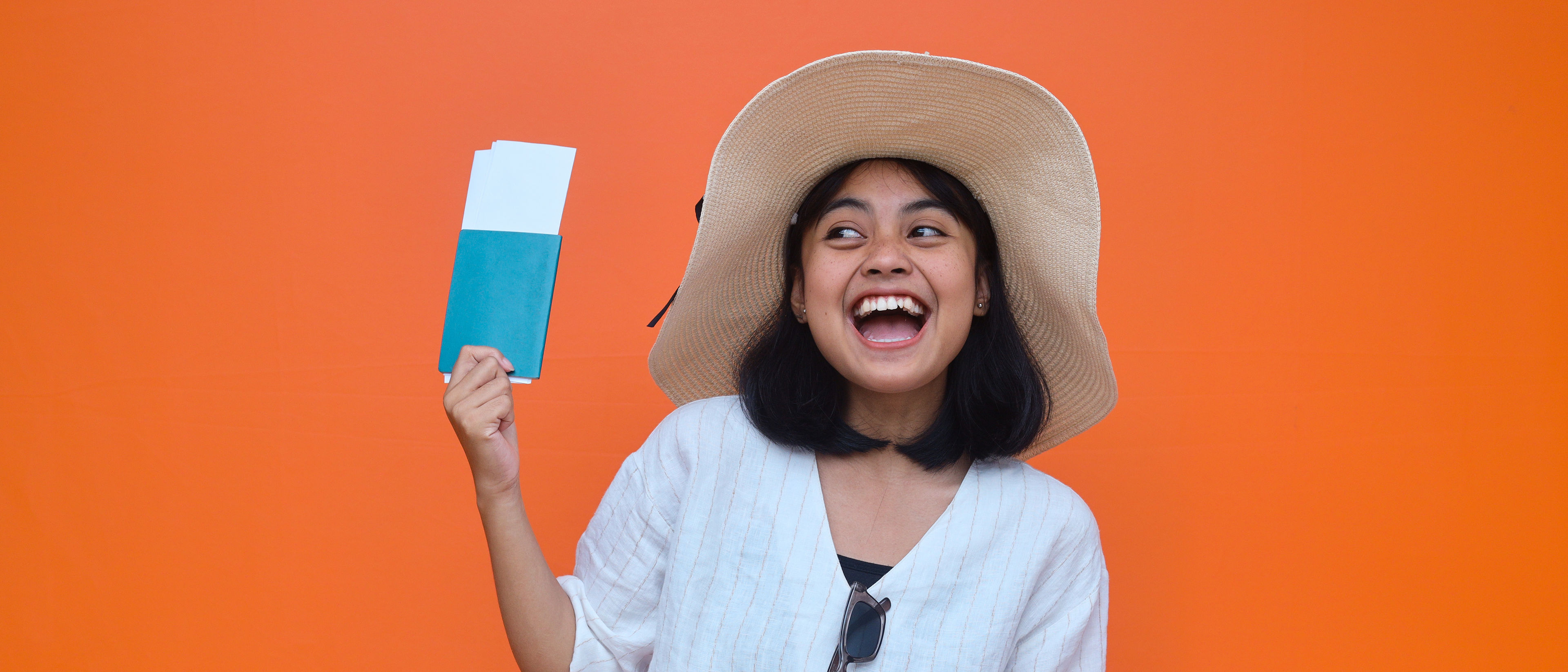 Smiling woman holding passport and tickets