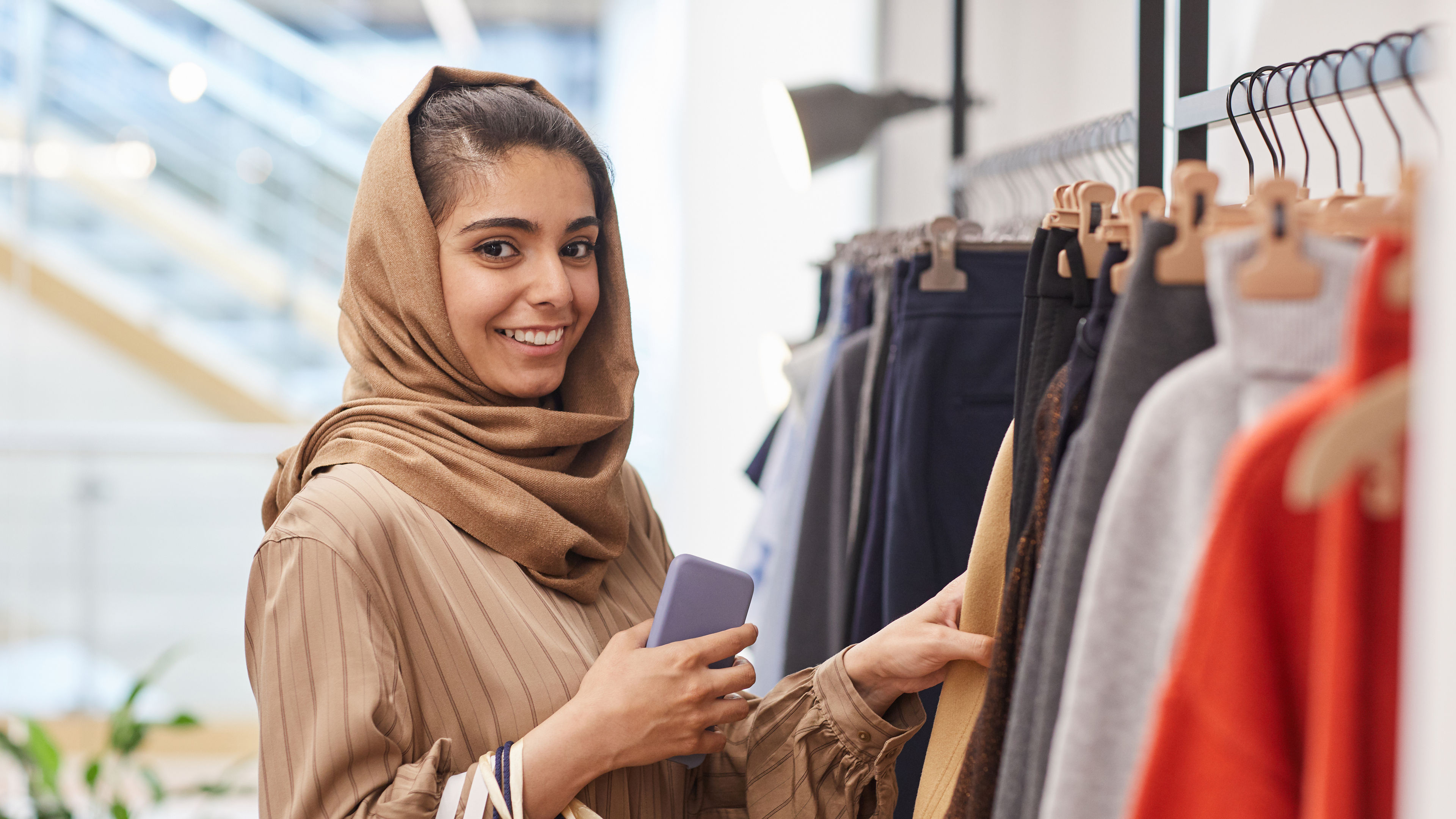 The woman is shopping for new outfits.
