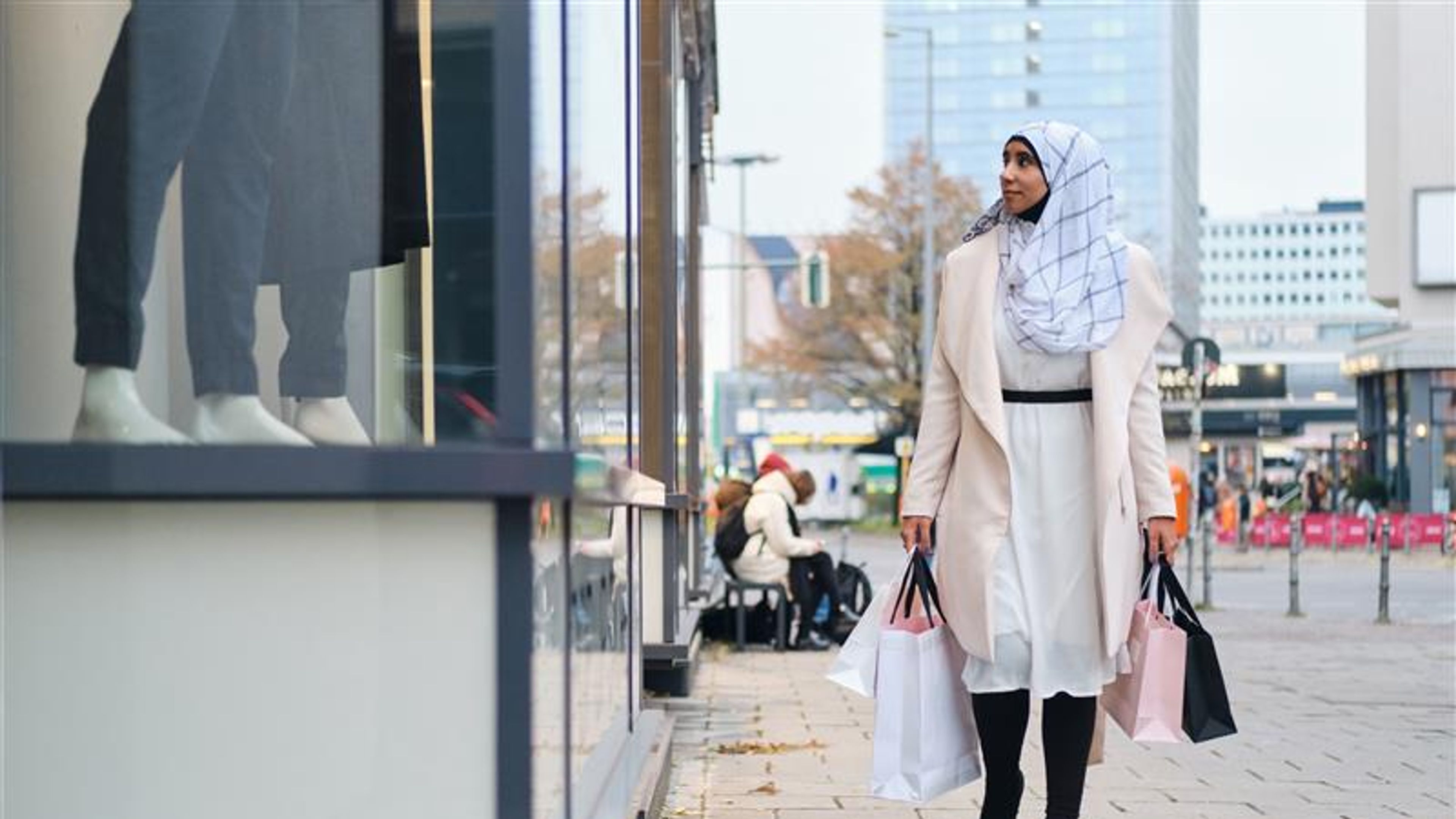 A woman in a city with shopping bags in hand 
