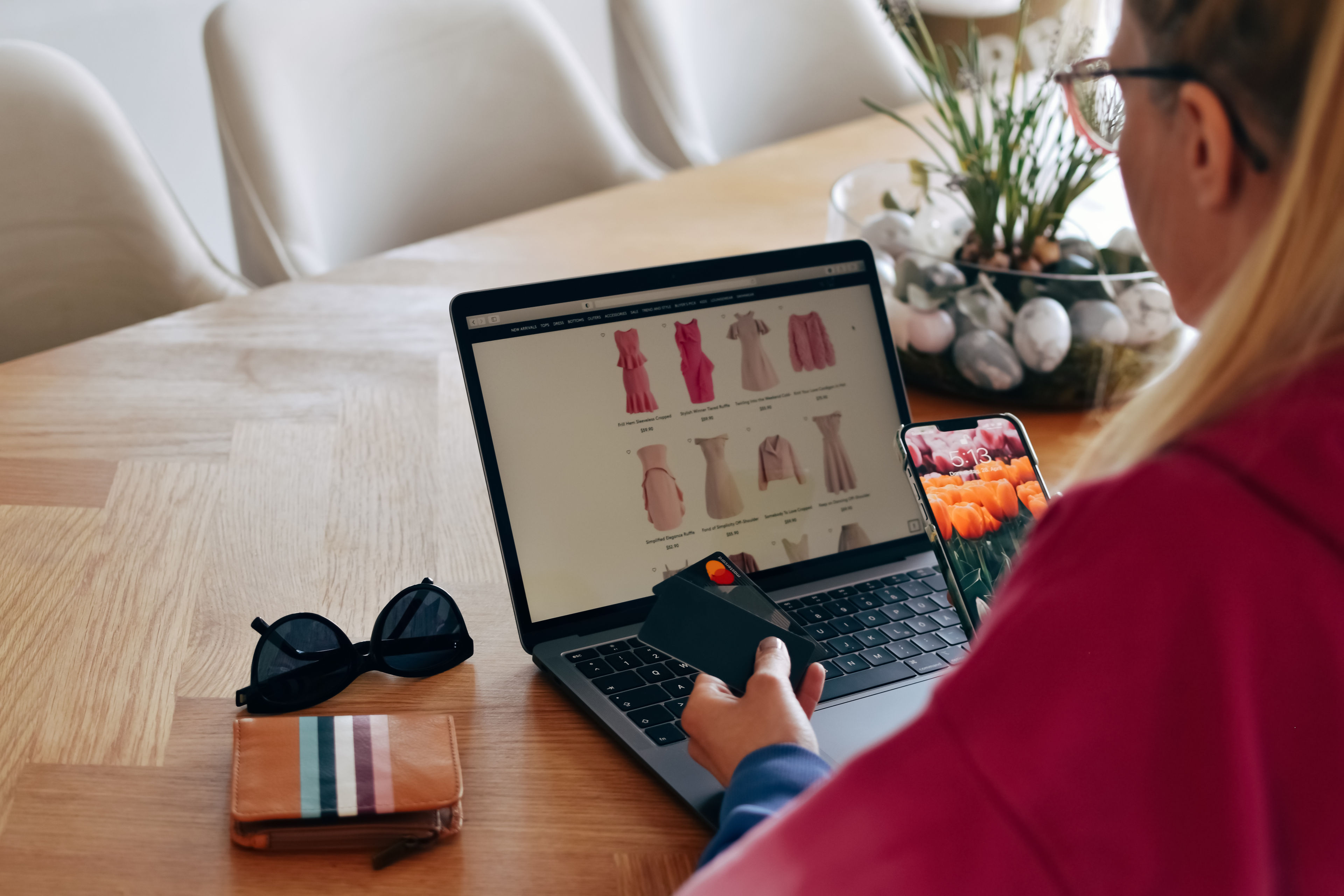 A woman is shopping for pink dresses online