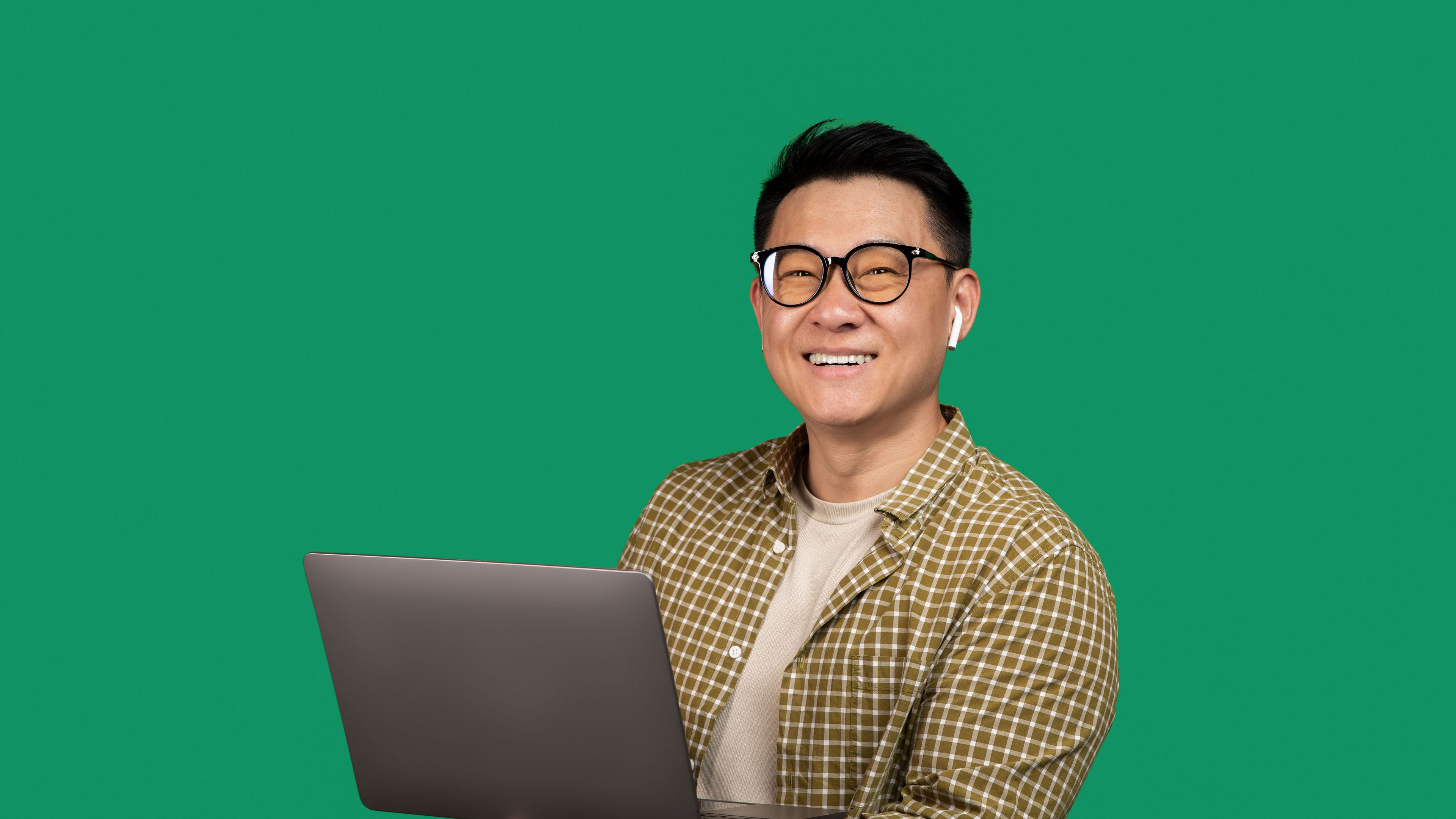 Positive asian man holding laptop computer and smiling 