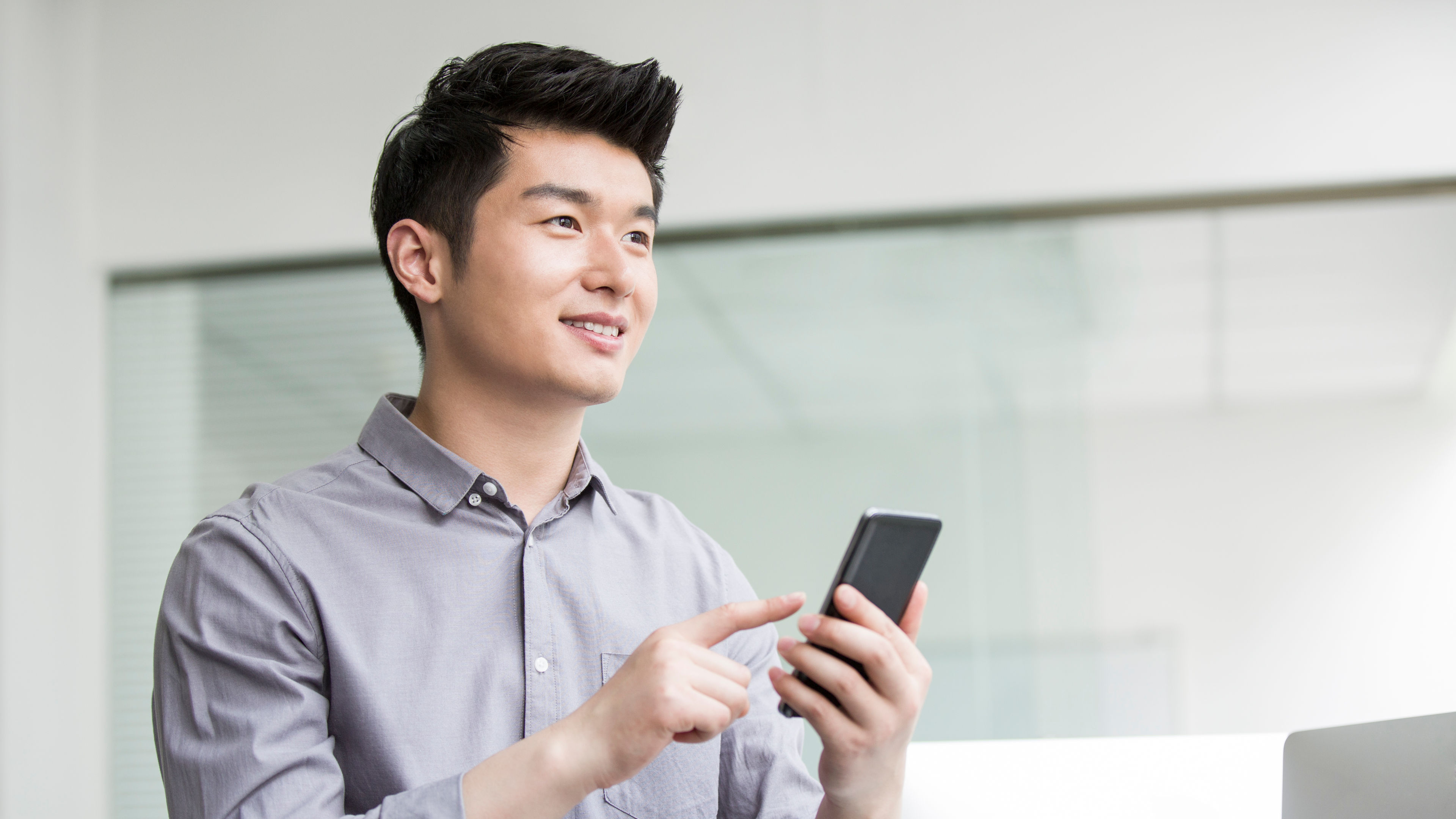 Young businessman using smart phone in office 