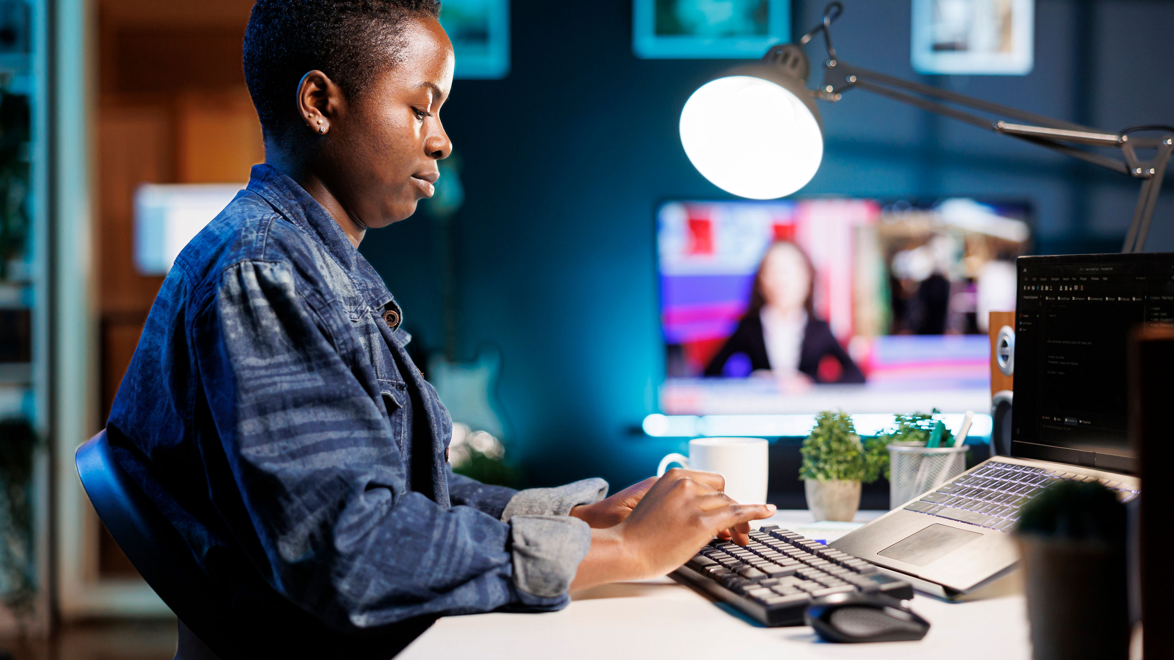 African female freelancer working on laptop, managing data, programming, and ensuring cyber security. 