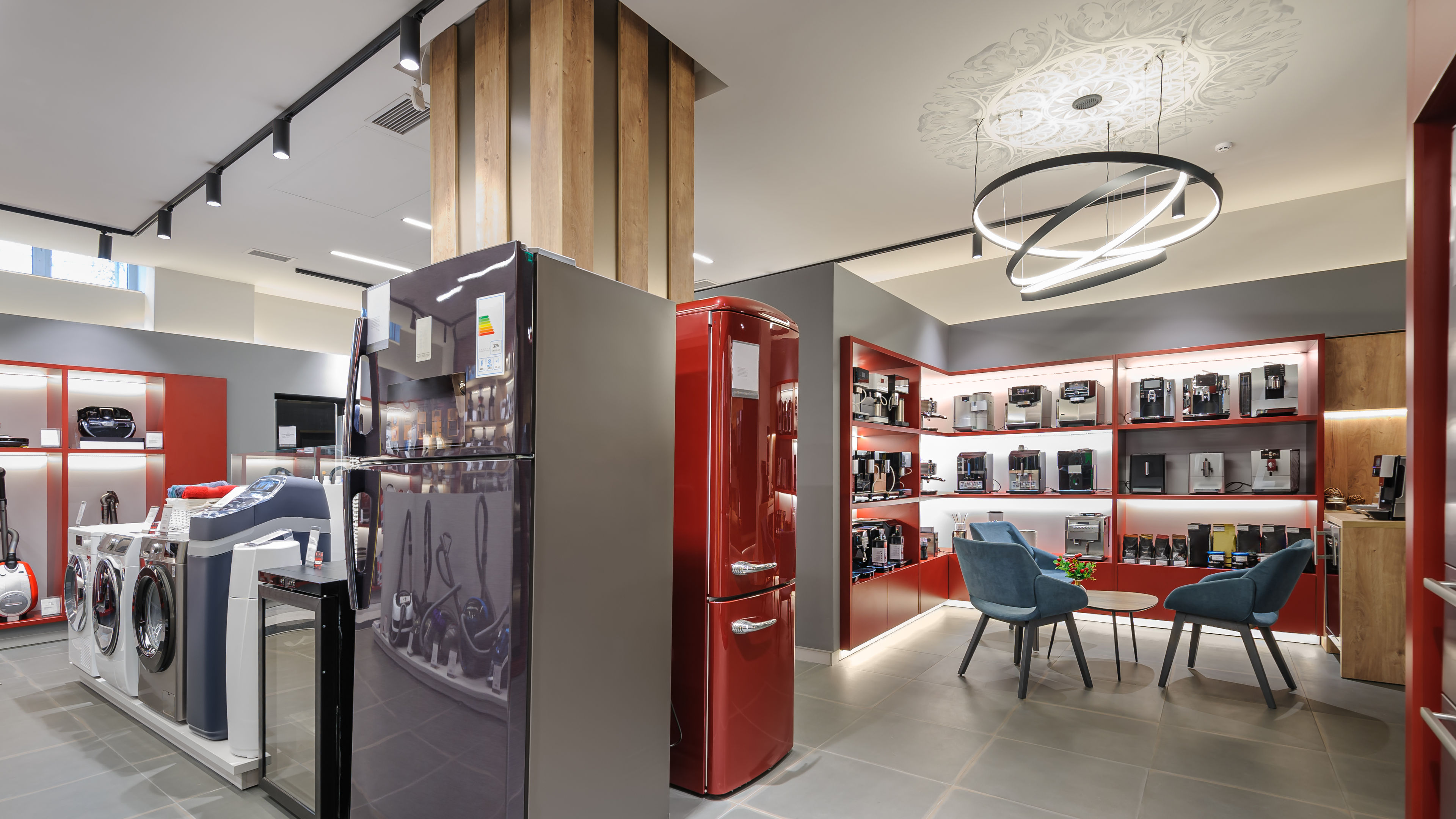 Premium home appliance store showcasing a fridge, washing machine, and chairs in the display.