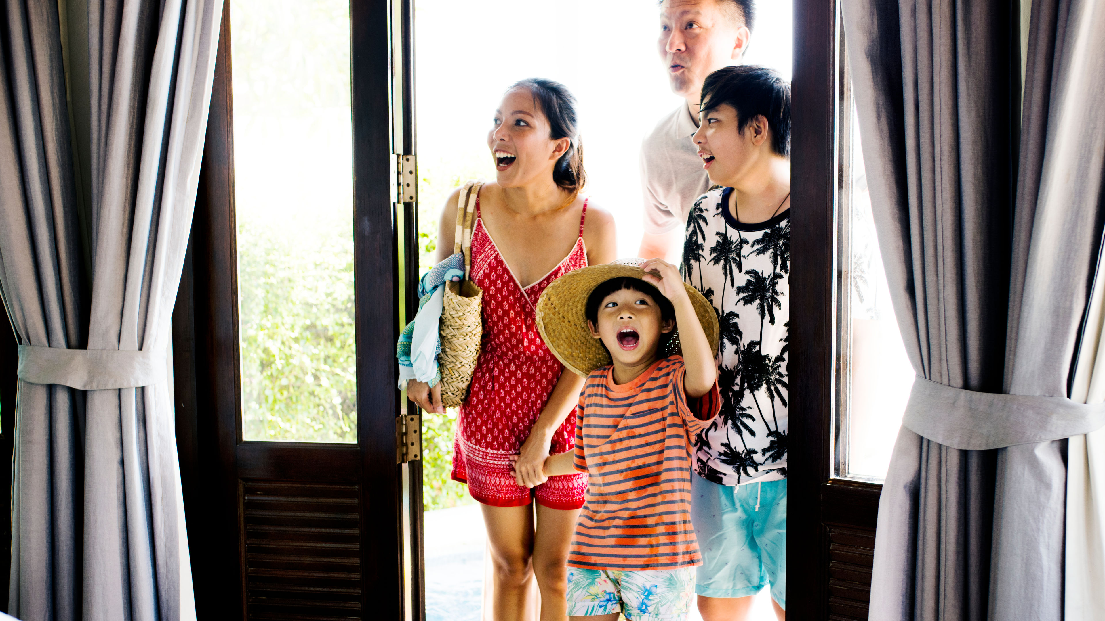 A family of four in a hotel with happy faces 